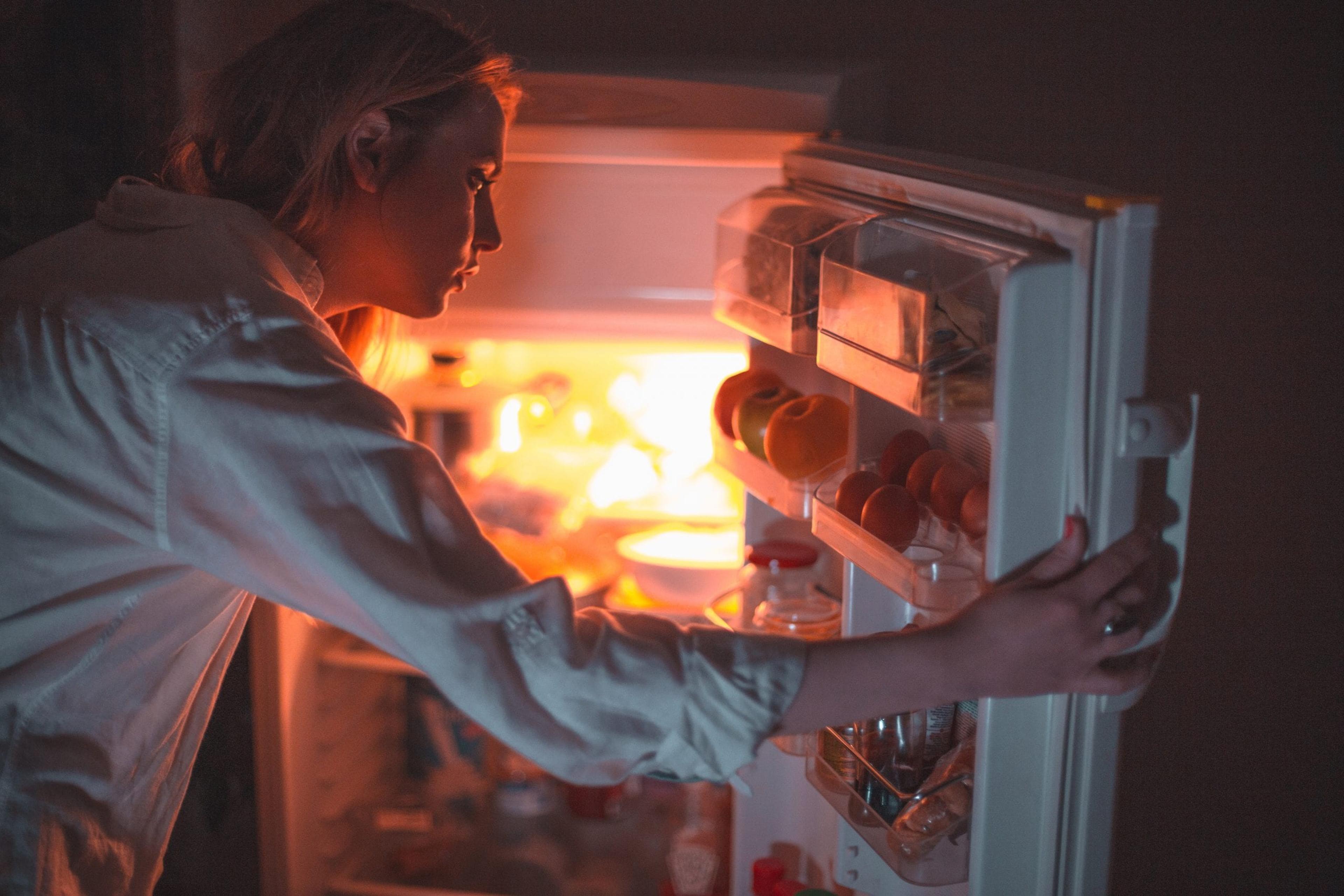 Young woman looking in the refrigerator