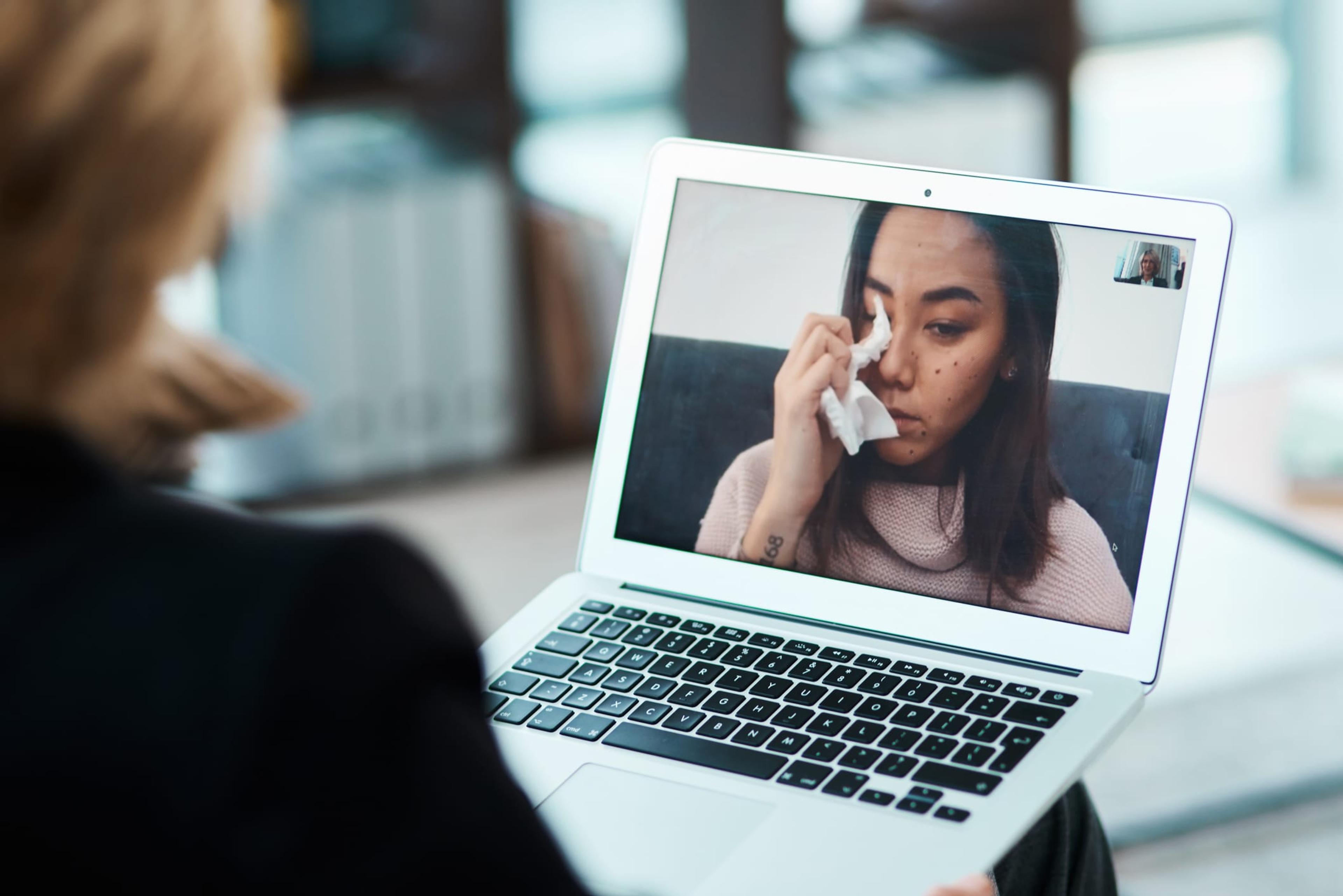 Woman crying during an online therapy session
