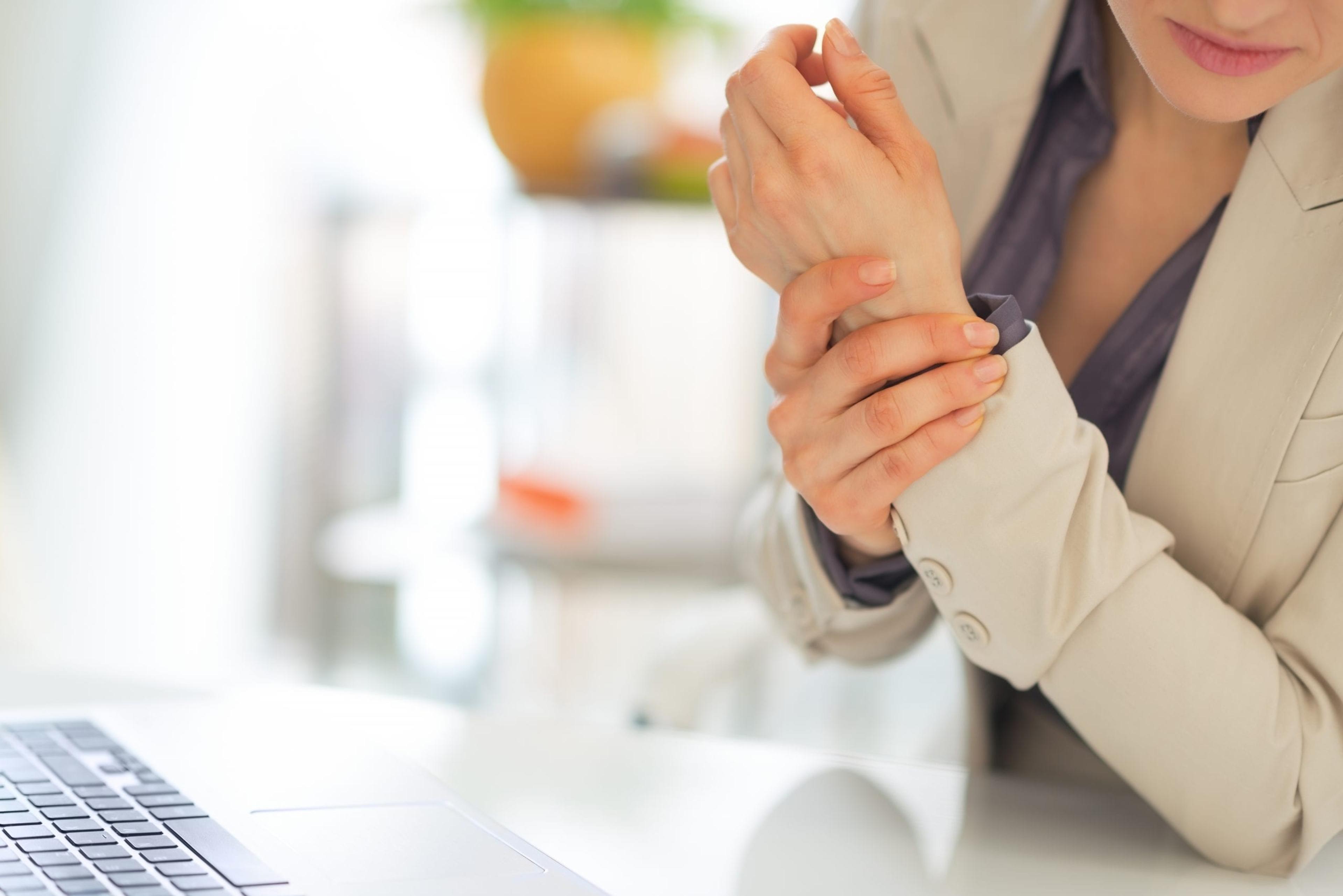 Closeup on business woman with wrist pain