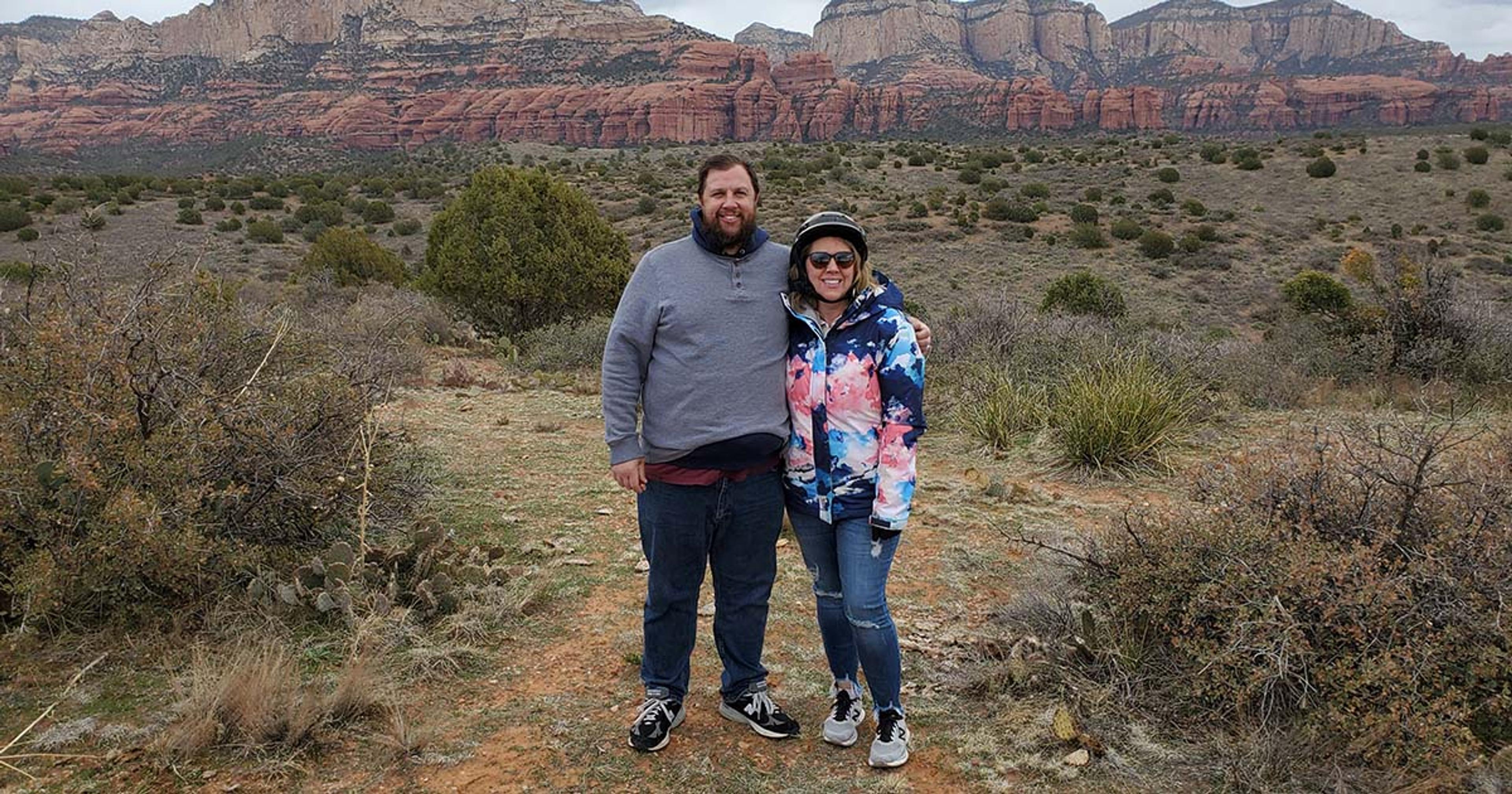 A woman and a man pose for a picture in the desert