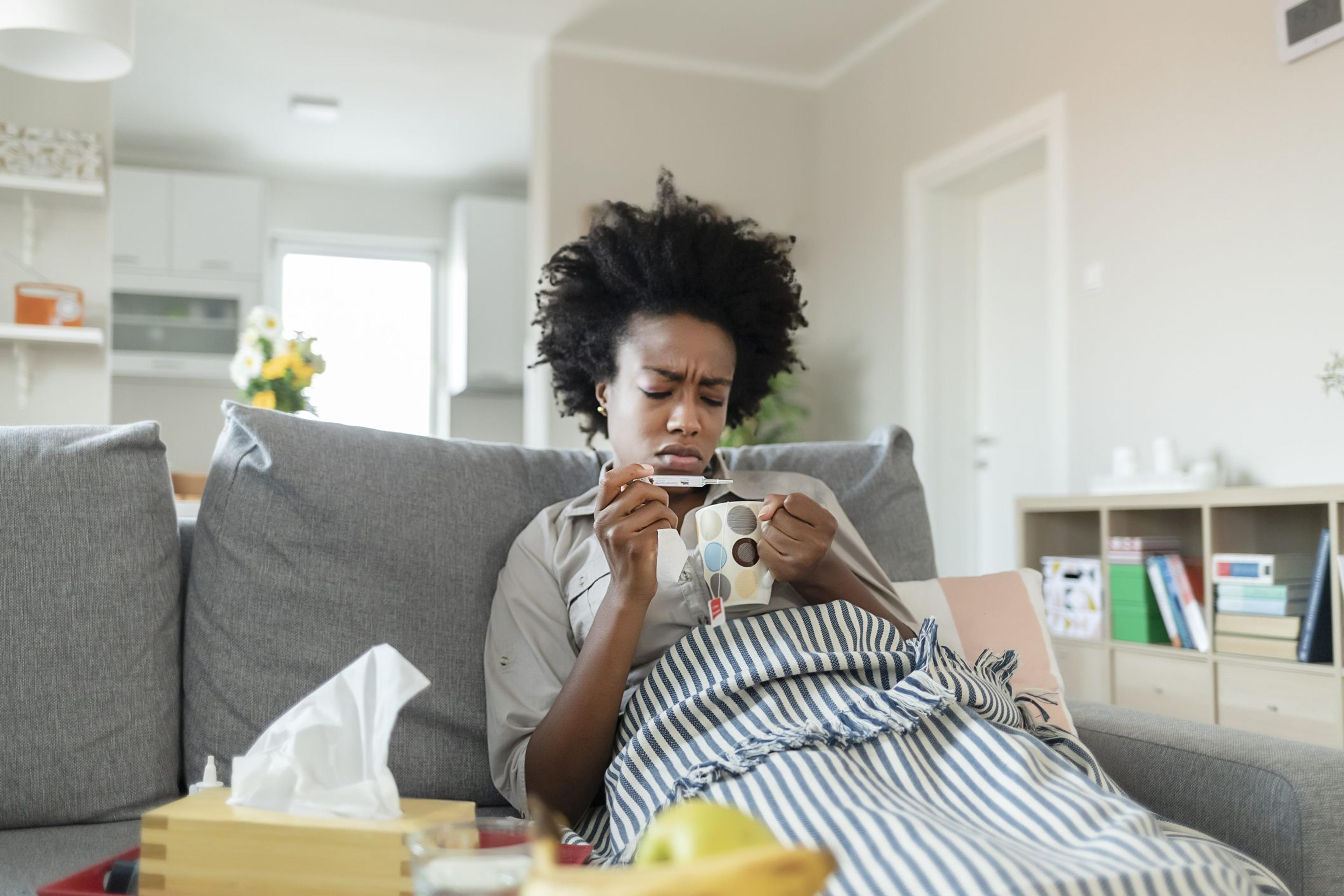 Woman Reading Her Temperature on a Thermometer at Home