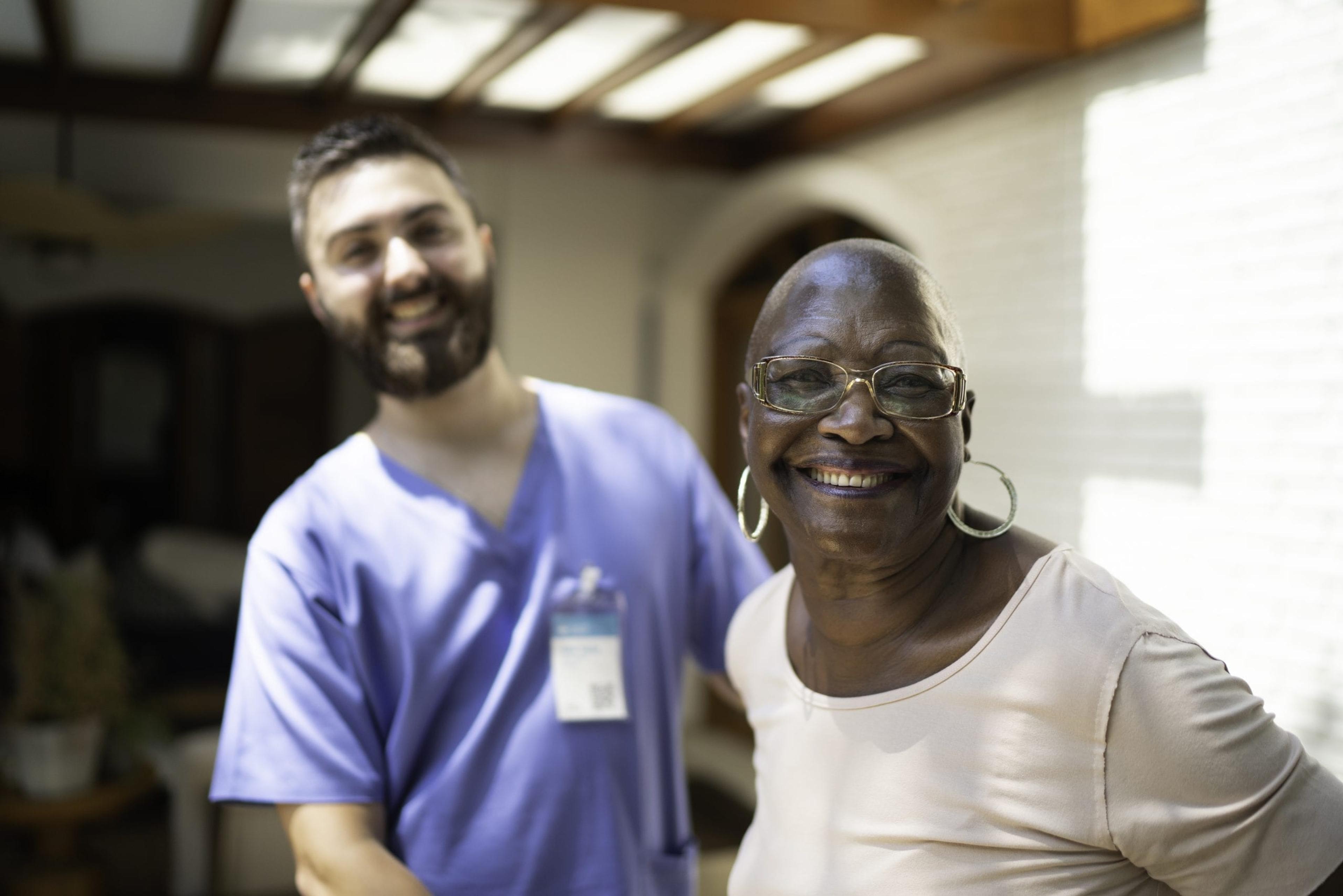 Health care worker posing with a woman in her home