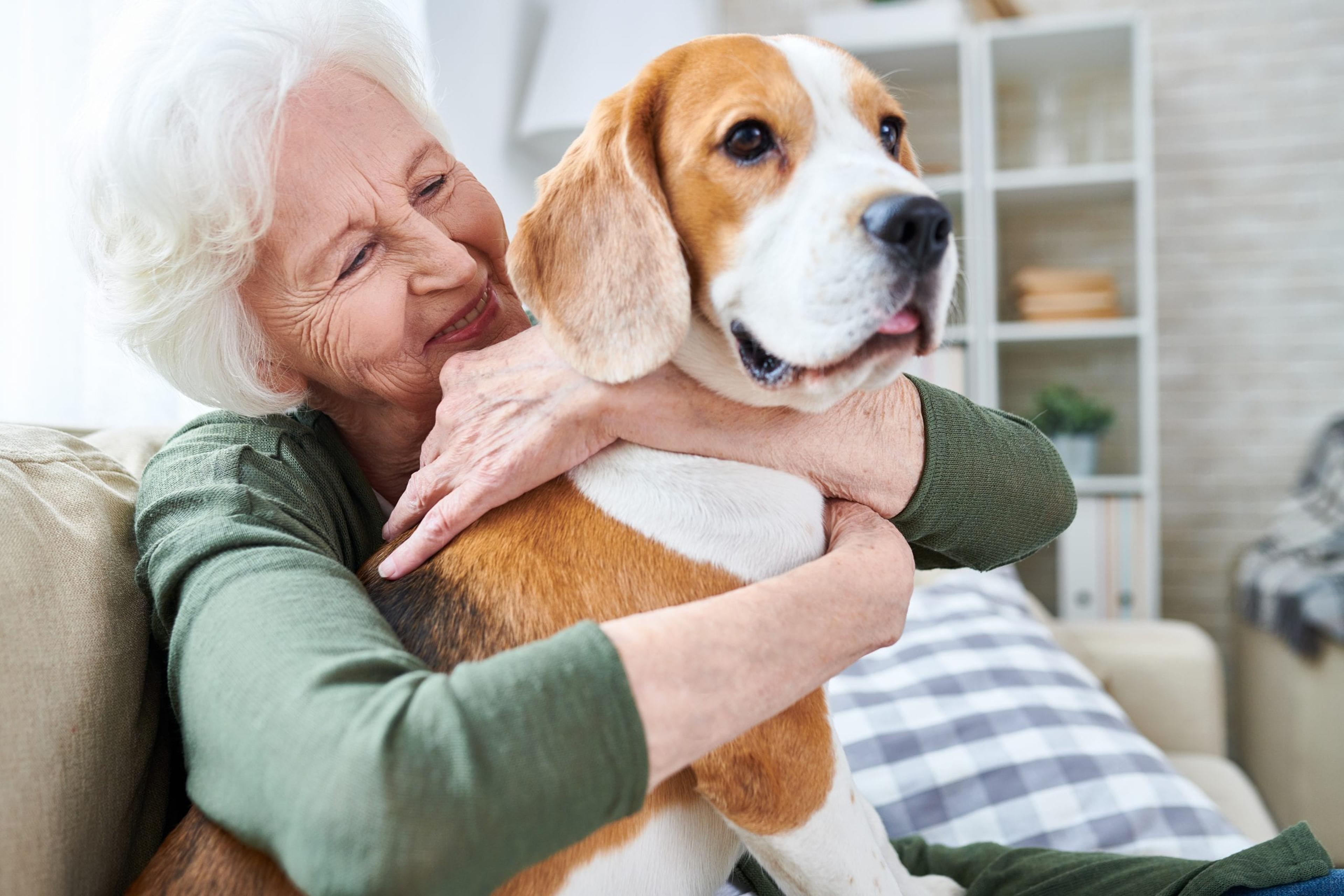 Older woman hugging a dog.