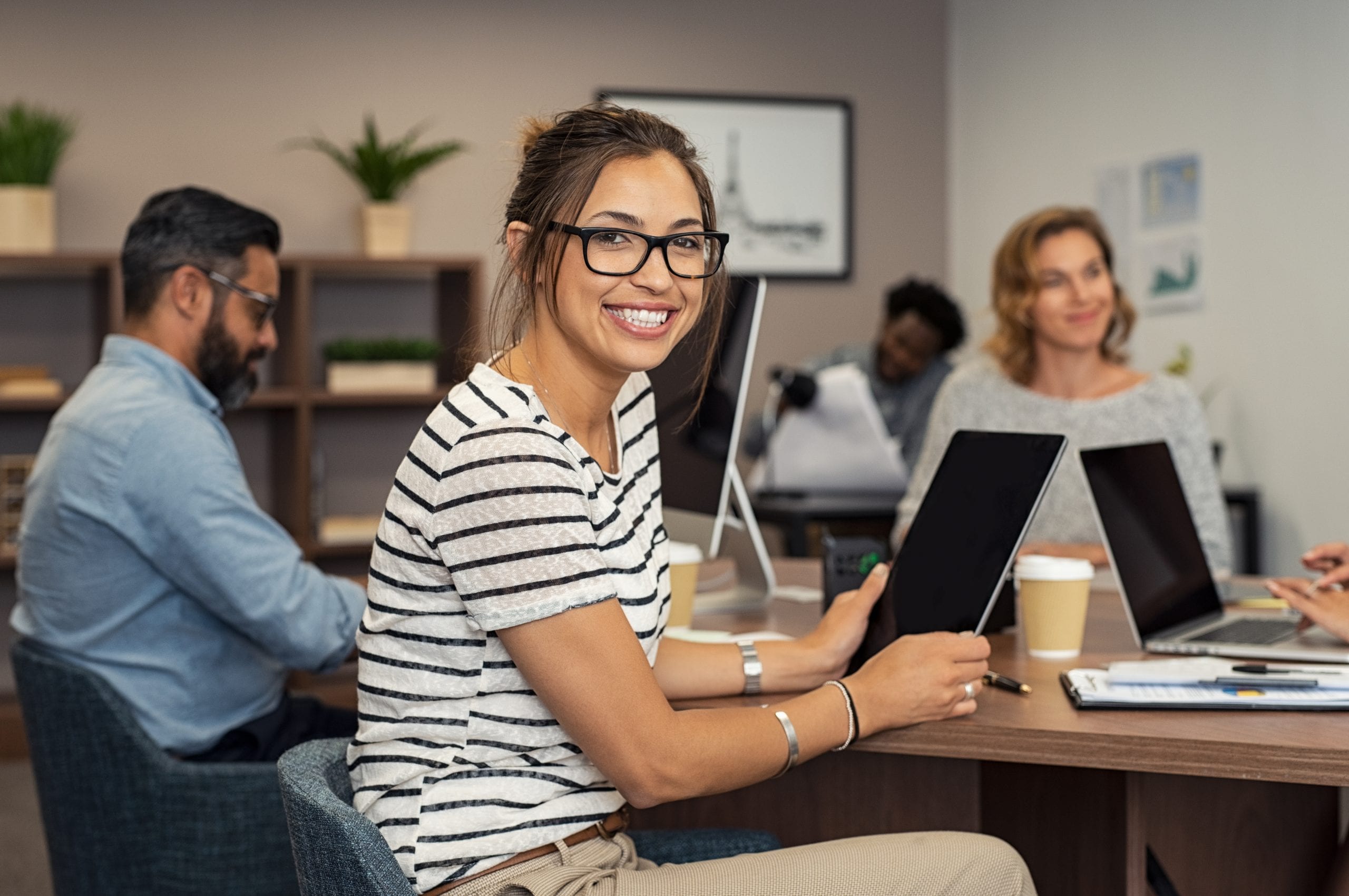 Случайная работа. Internship. Женщина на работе смотрит в камеру. Люди смотрят в камеру в офисе Сток. Фото Мировых победителей Сток в офисе.