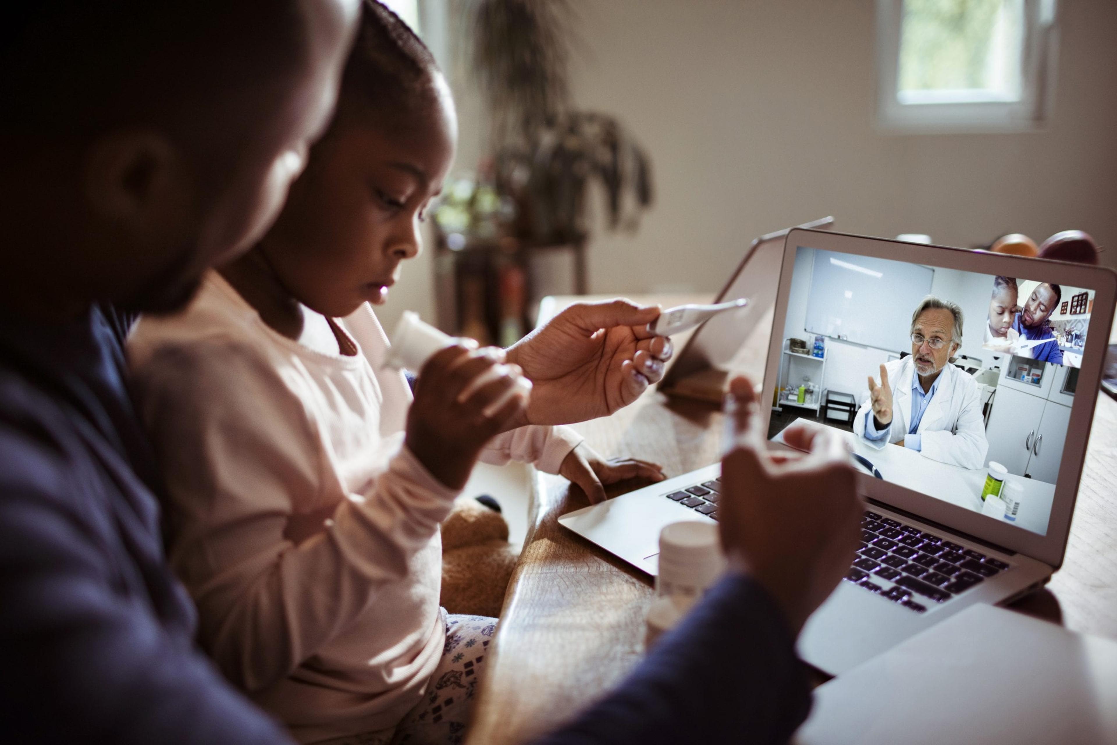 Father and daughter talking to a doctor online