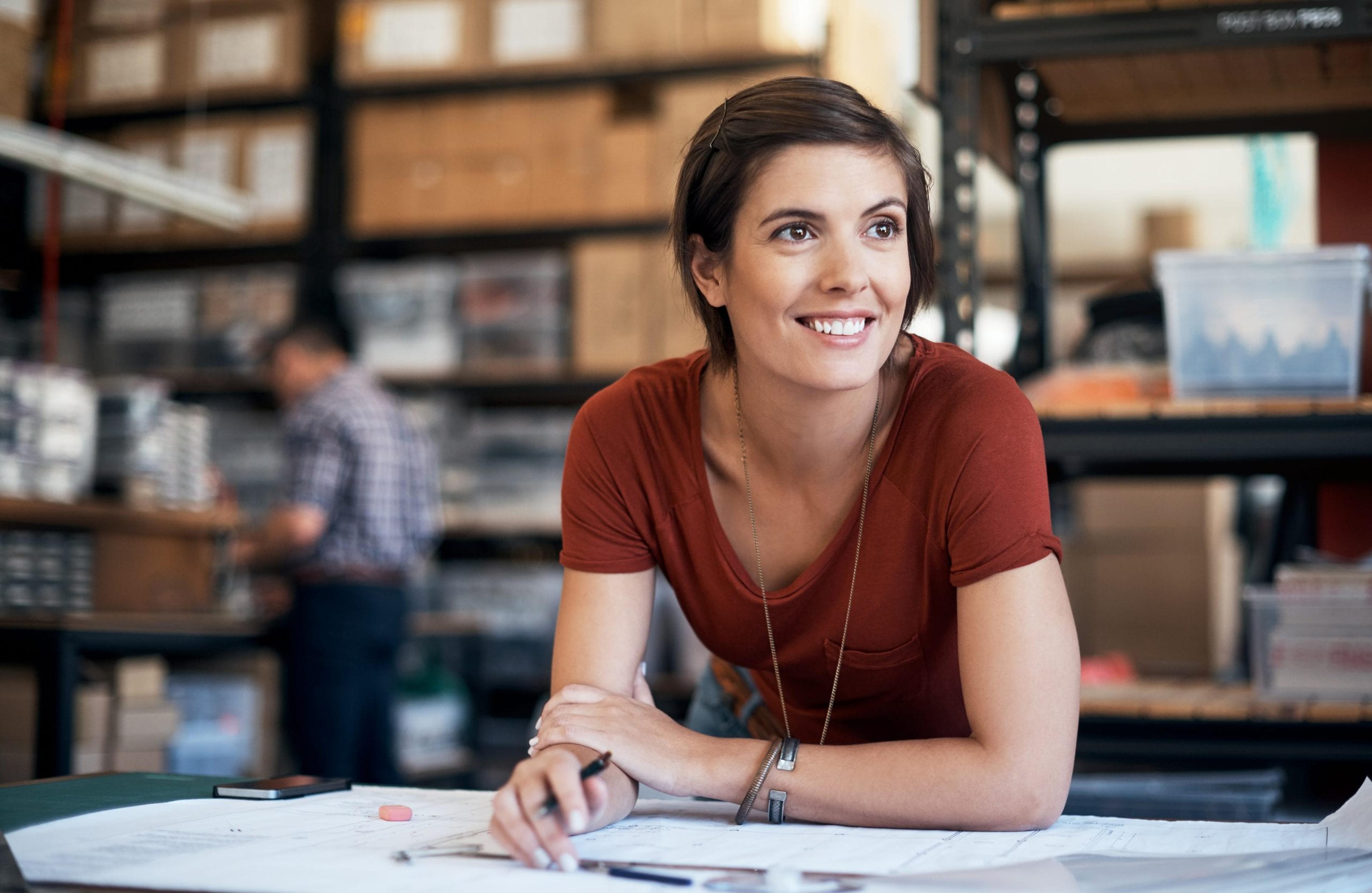 Small business owner sketching out plans in a workshop.