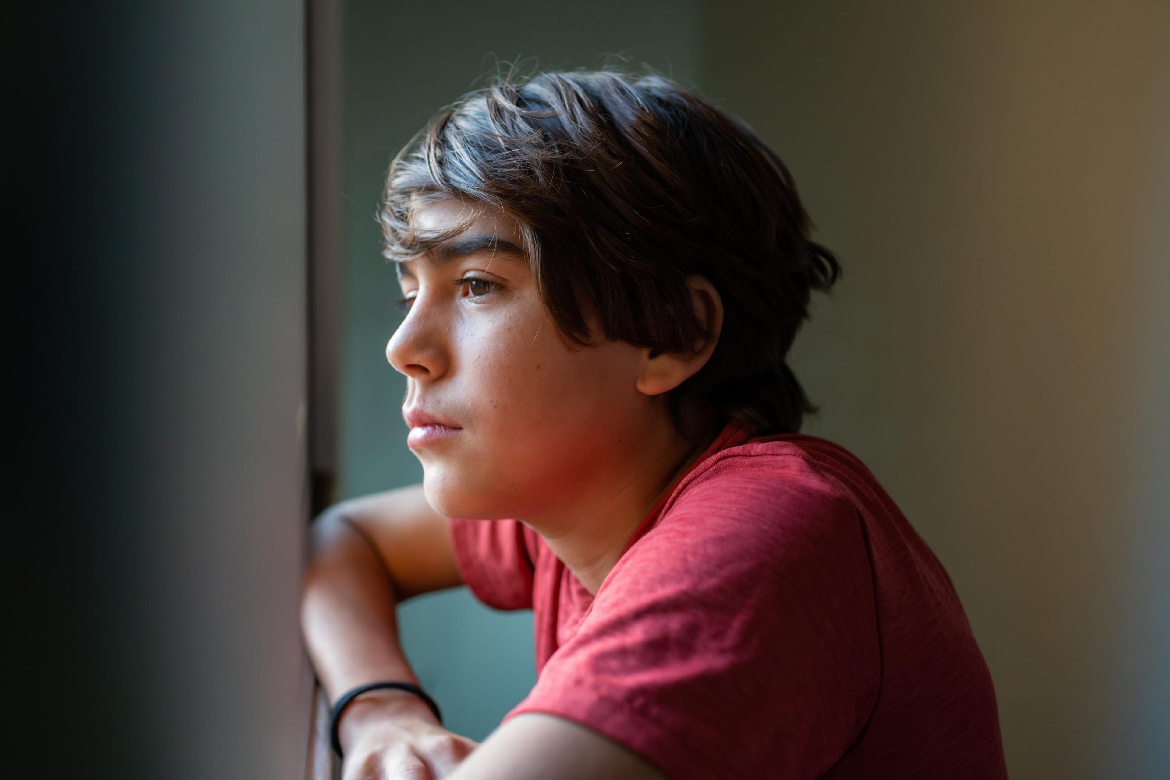Young man looking out window