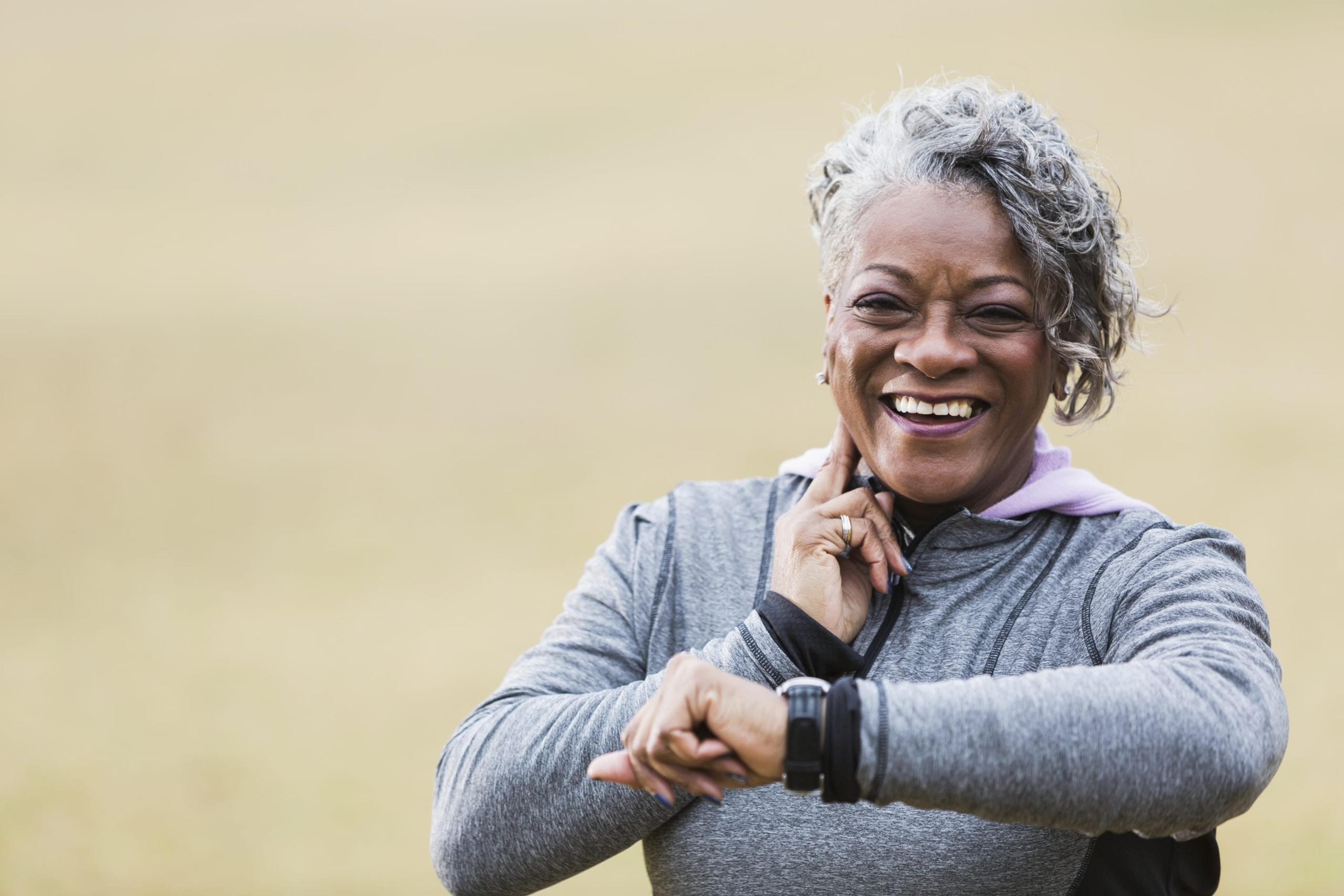 Older African American woman exercising and taking her pulse.