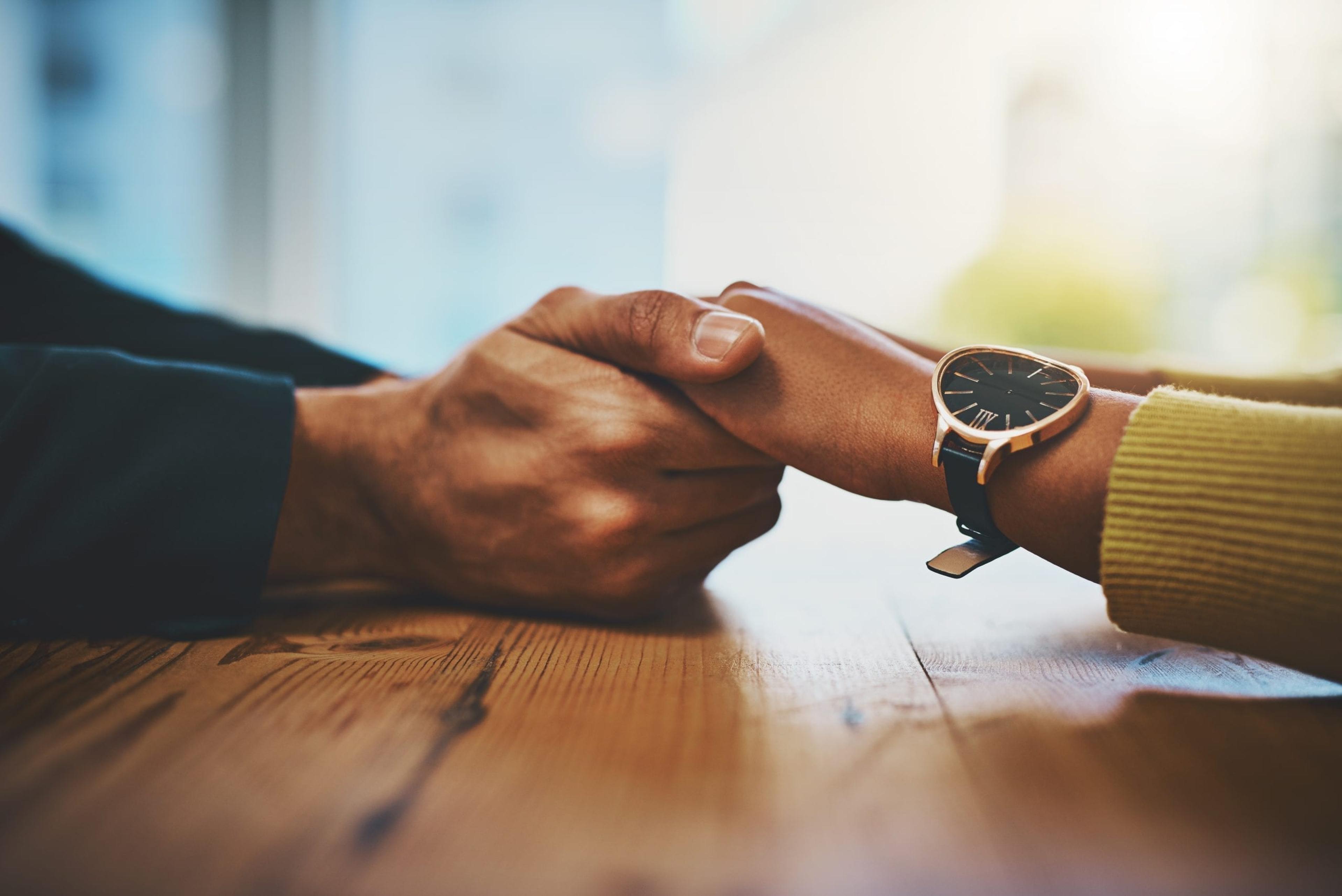 Couple holding hands across a table