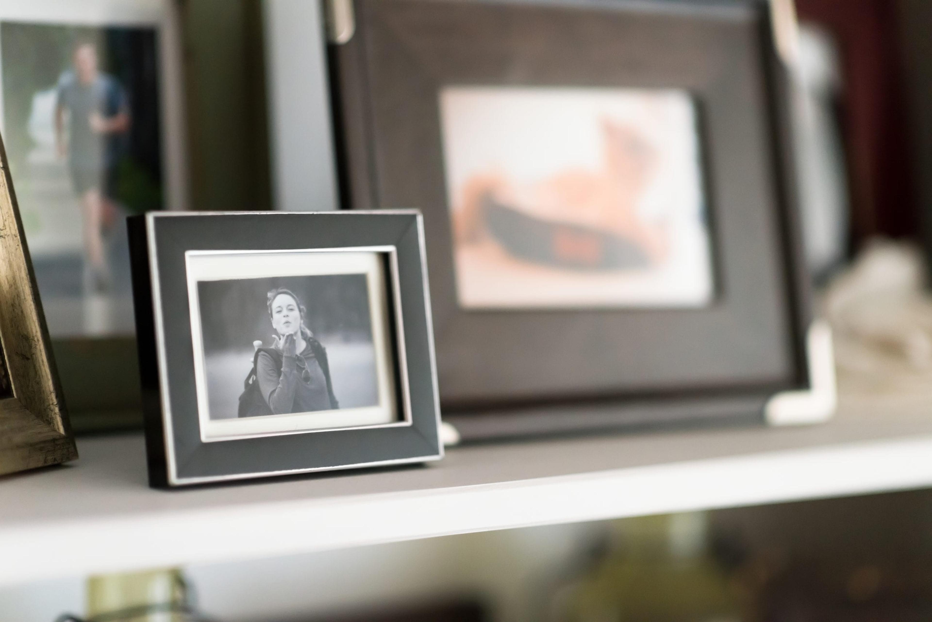 Framed black and white image of a woman on a mantel.