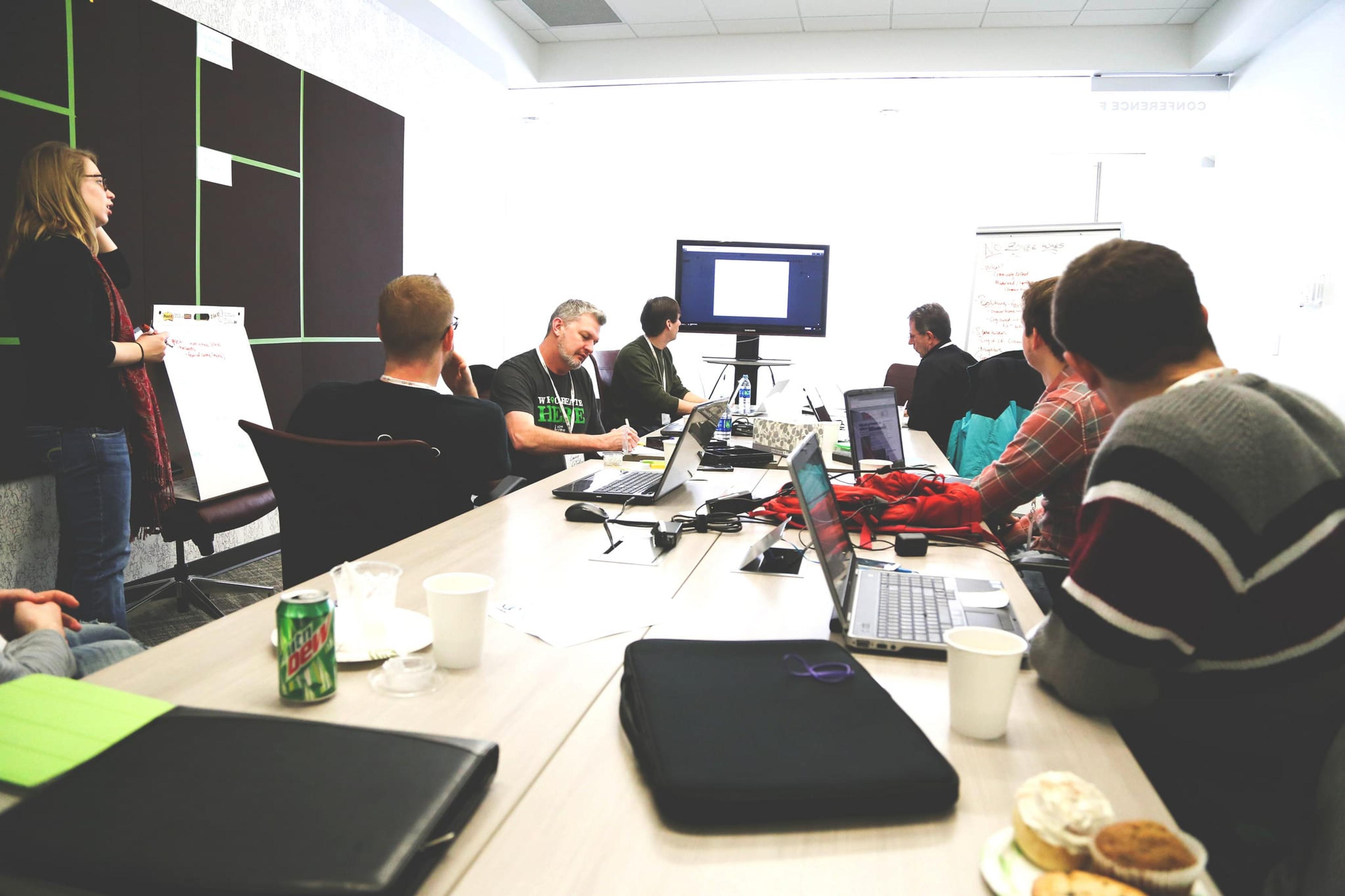 small group of people with computers working around a table.