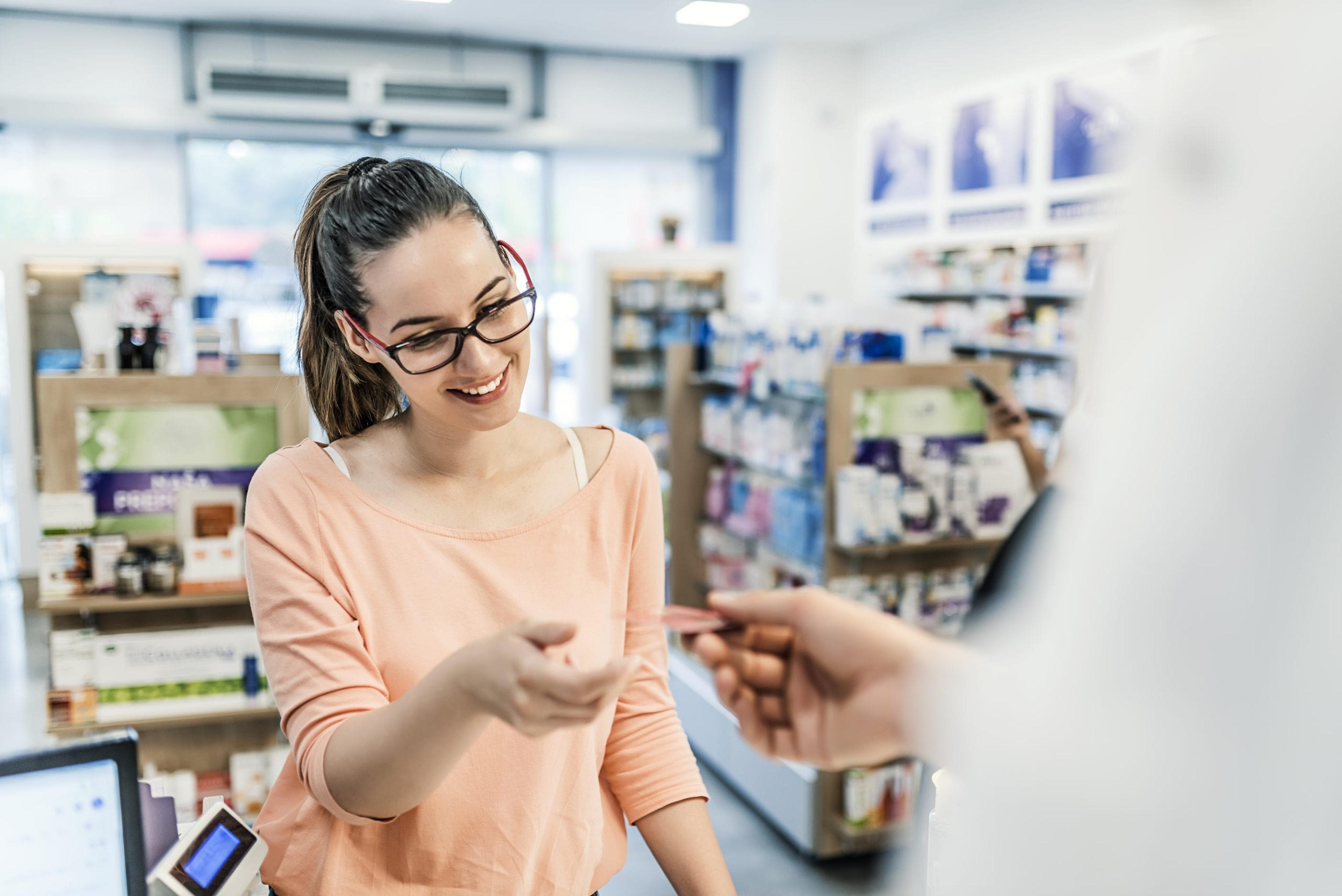 Woman handing card to pharmacist