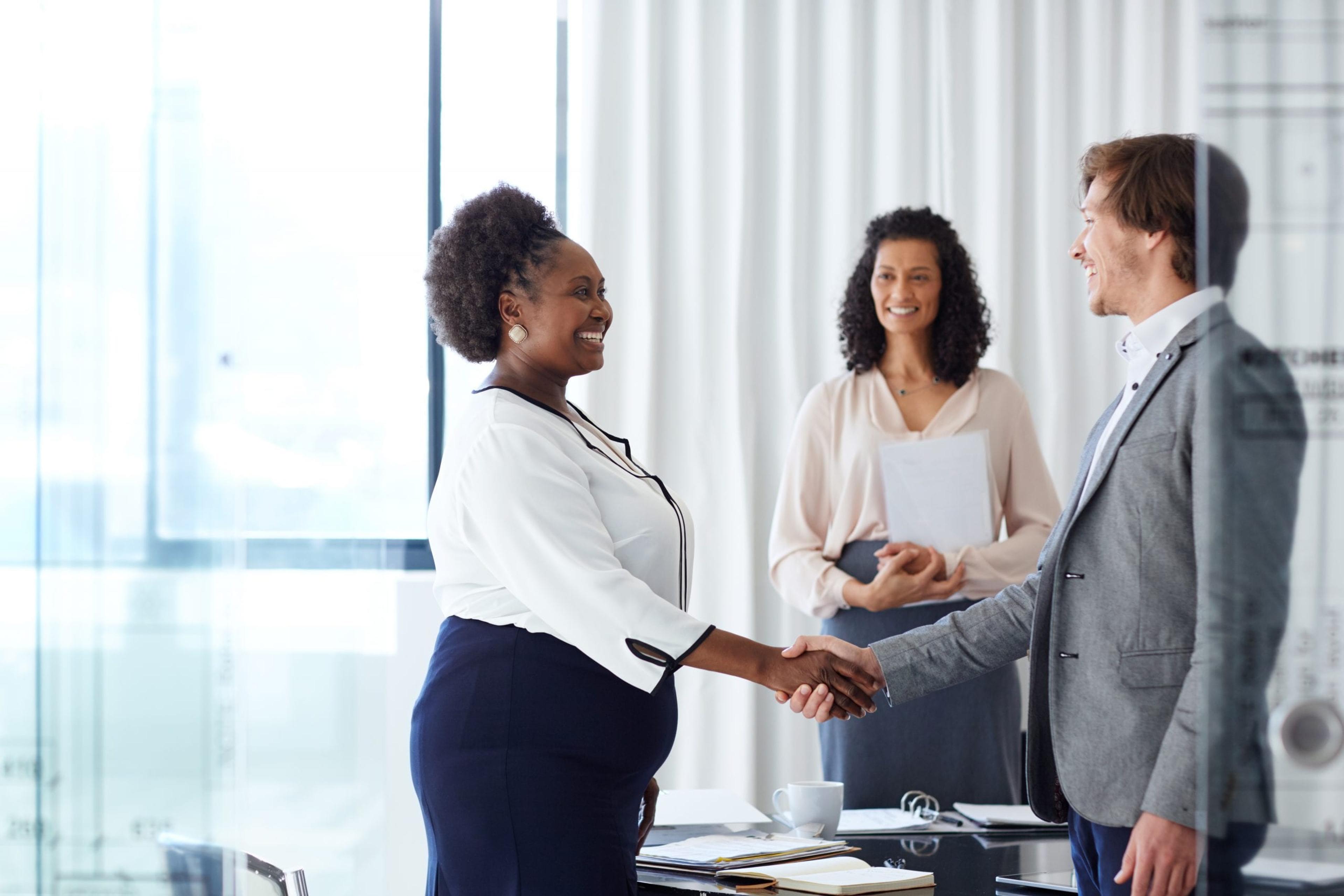 Man and woman shaking hands during a business deal.