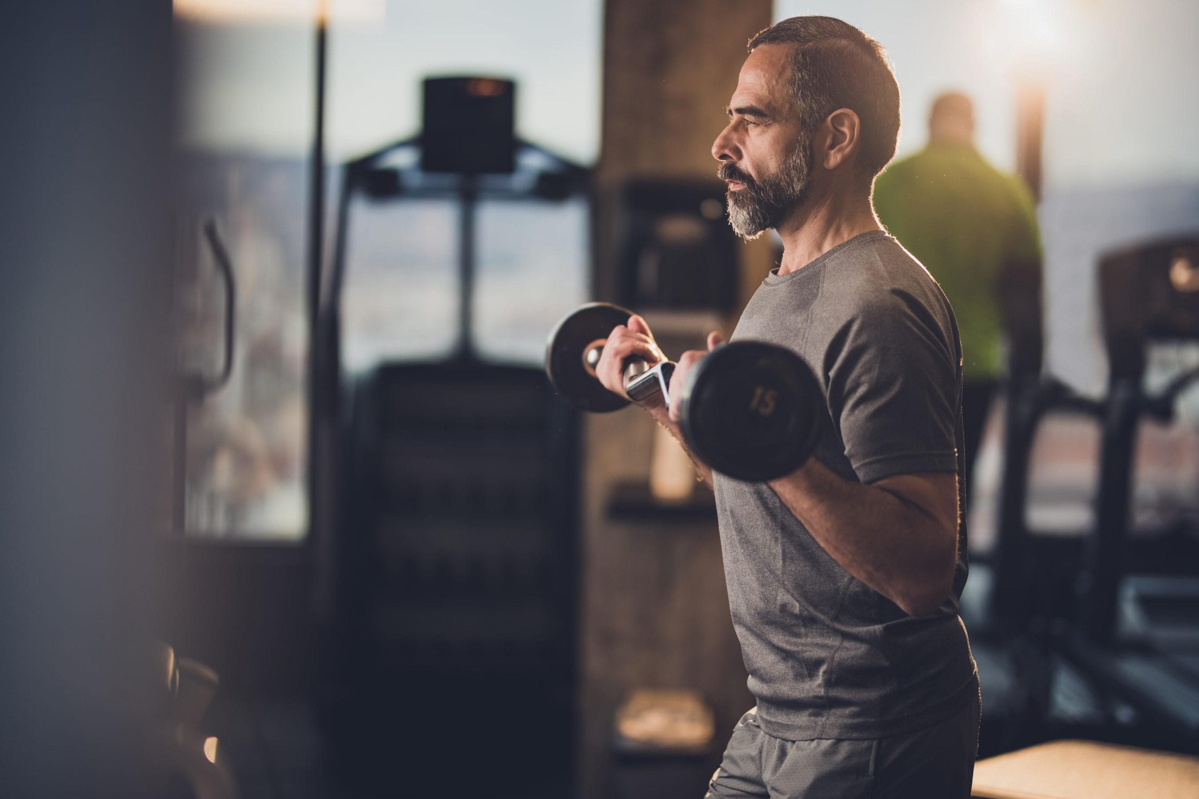 Older man exercising by lifting weights.