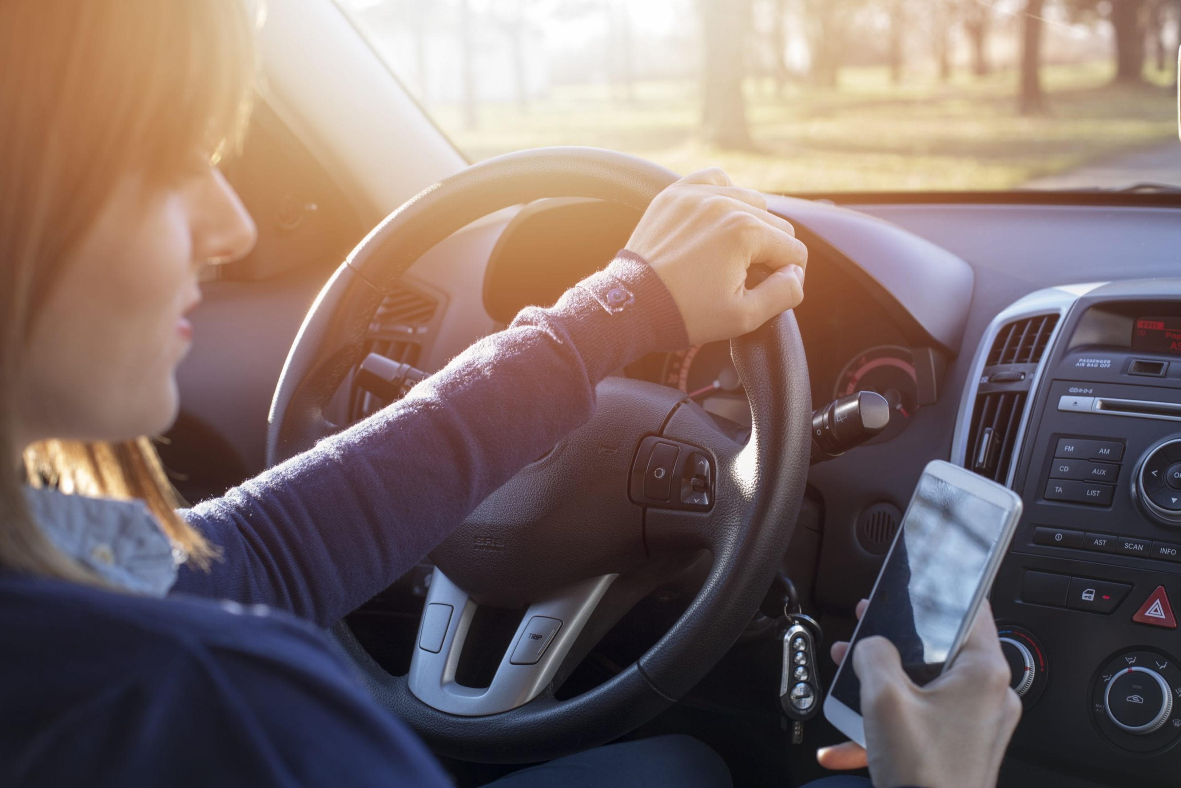 Woman looking at her phone while driving