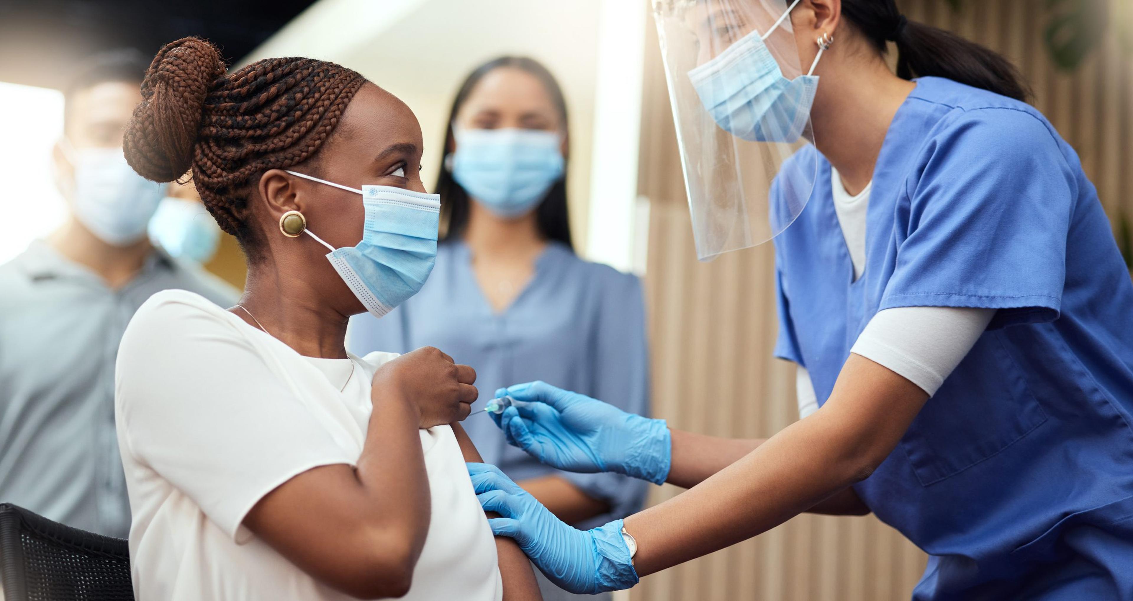 Woman getting a COVID booster shot from a nurse