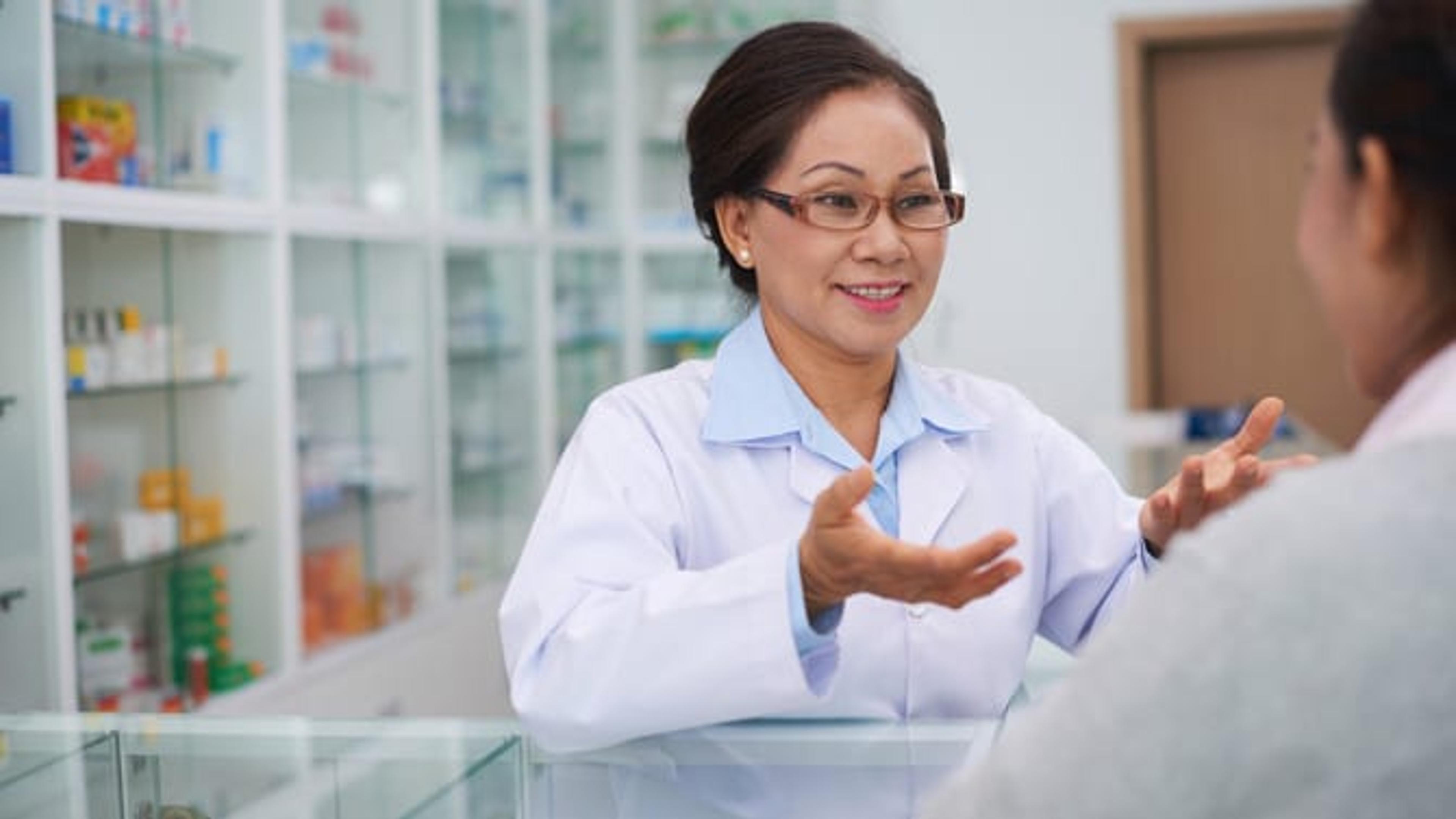 Pharmacist speaking with customer.