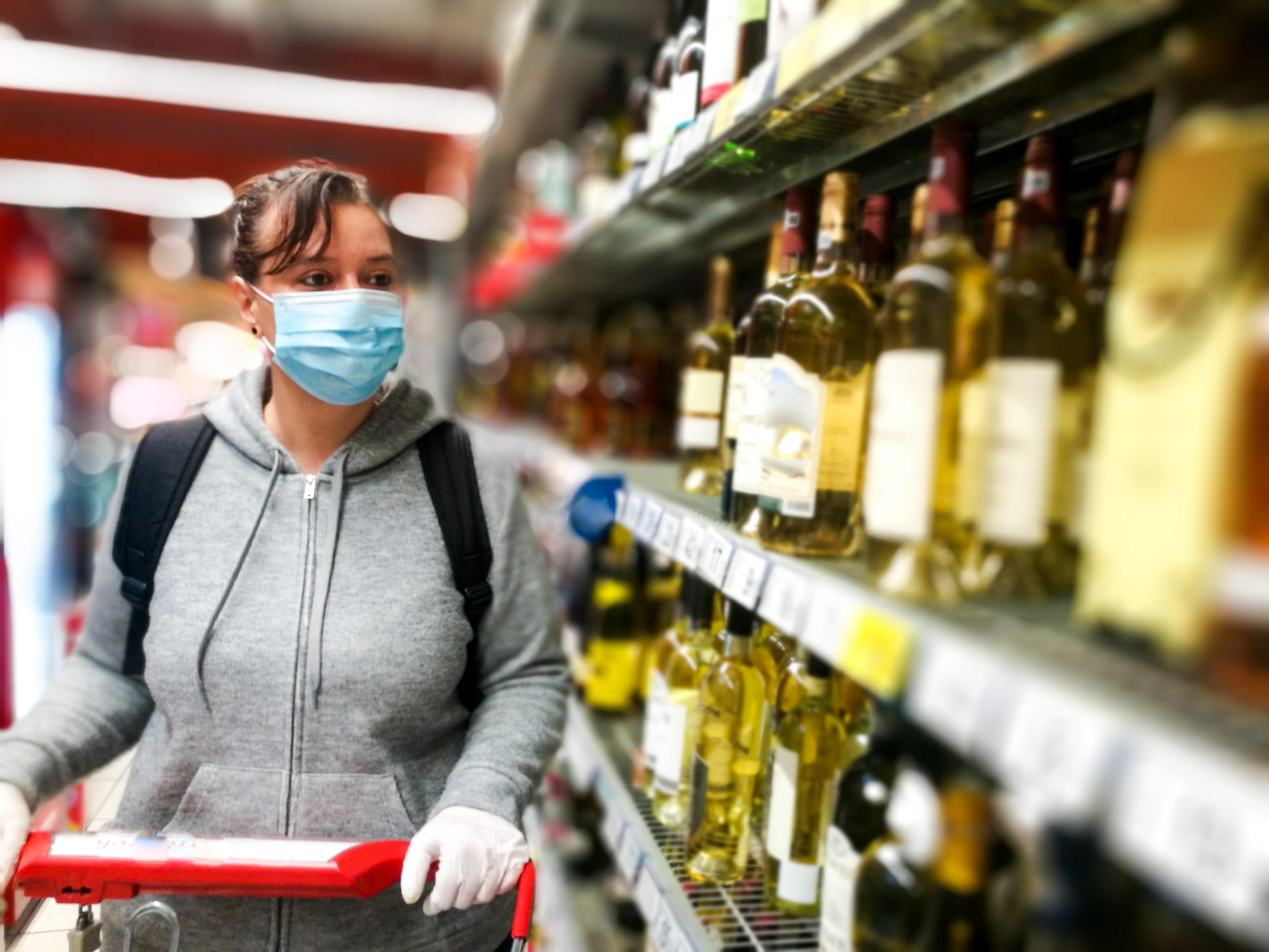 Woman shopping for alcohol with face mask on