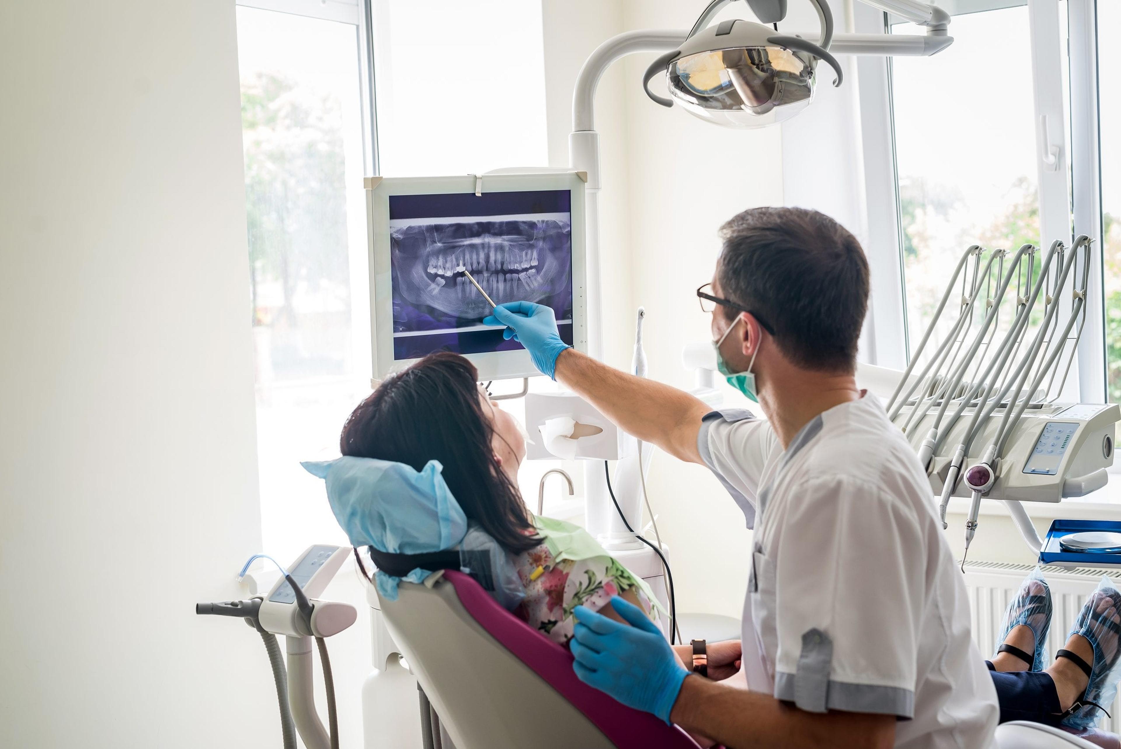 Dentist pointing out x-rays to patient.