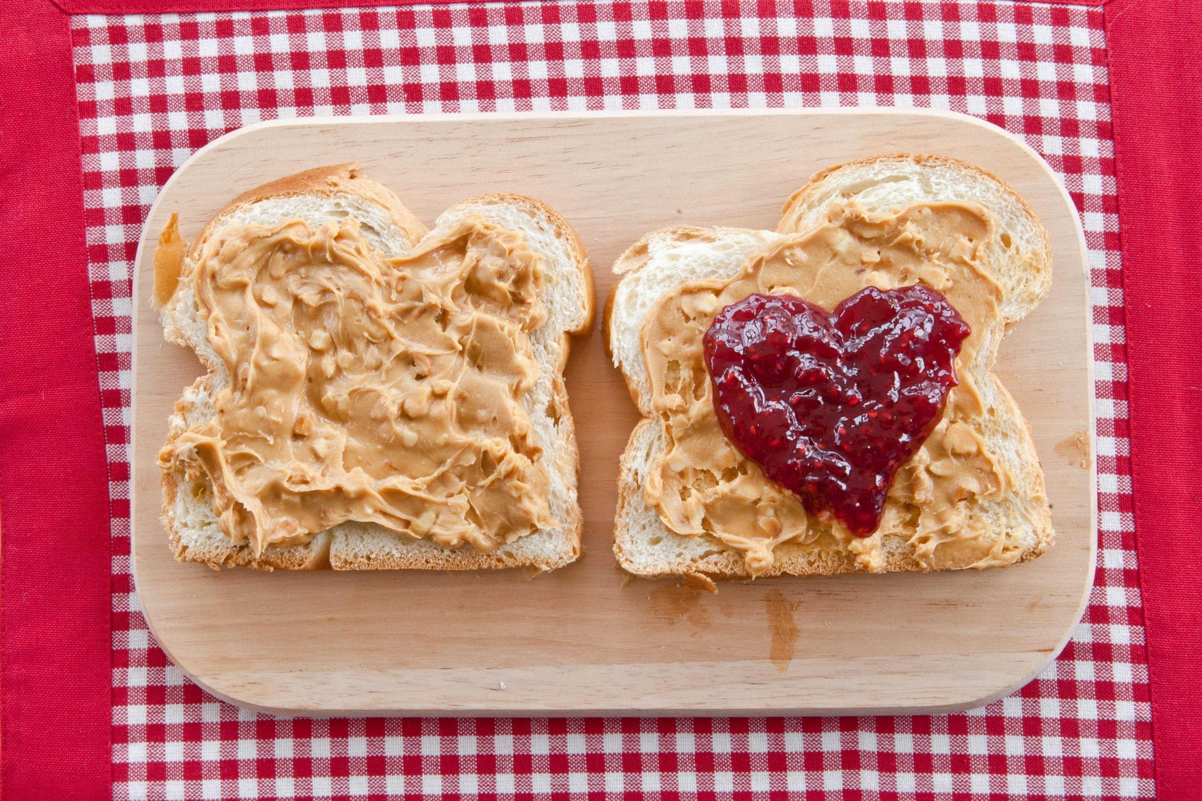 Bread spread with peanut butter and jelly in the shape of a heart.