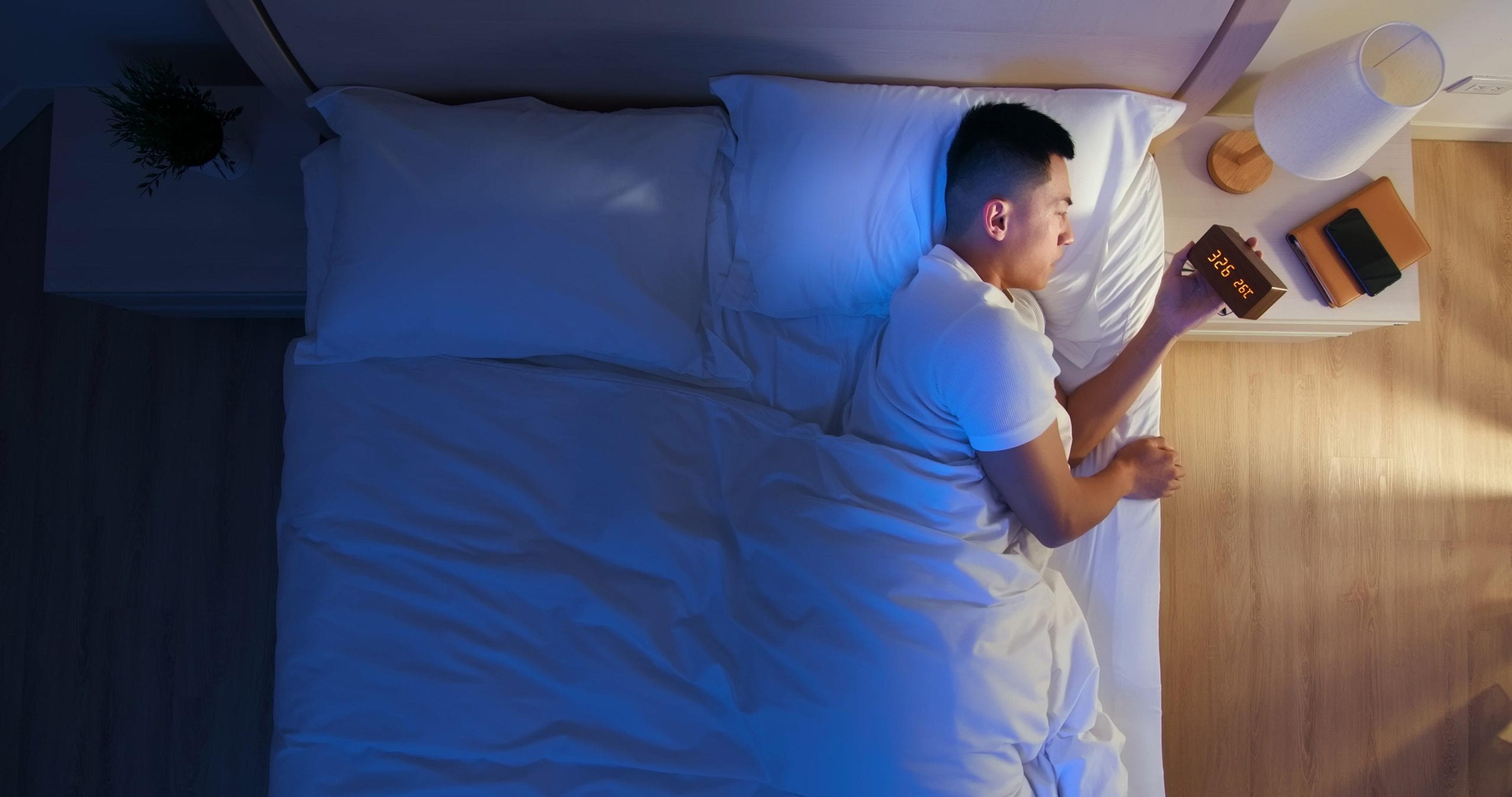 Man with disrupted sleep lying in bed in the middle of the night