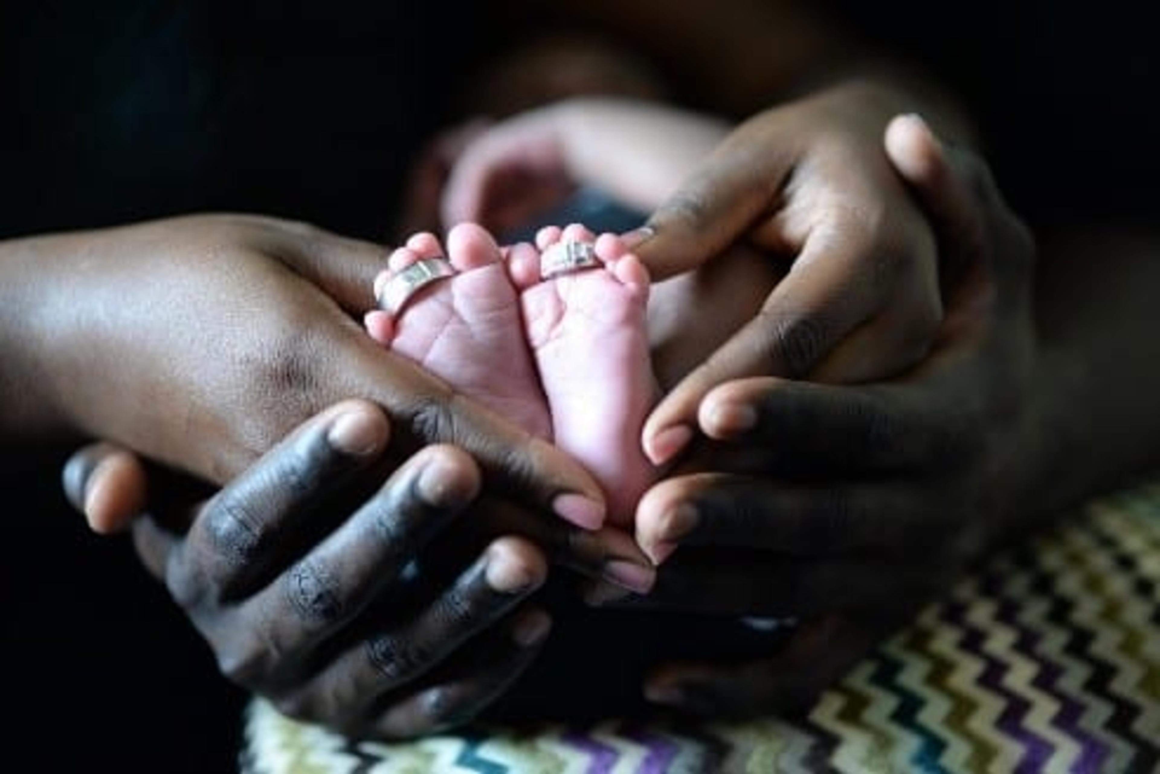 Parents holding babies feet