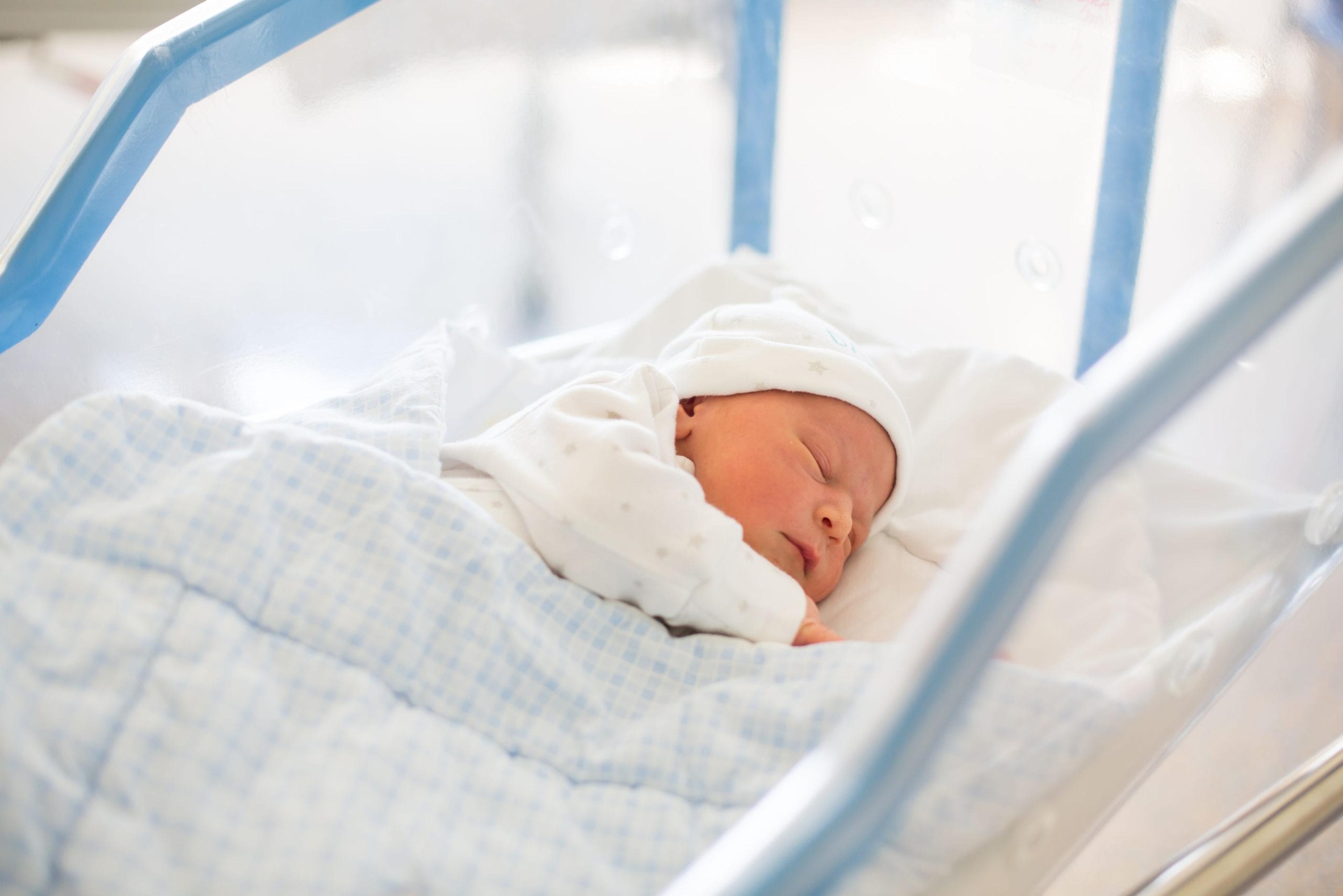 Image of a newborn sleeping in a hospital crib.