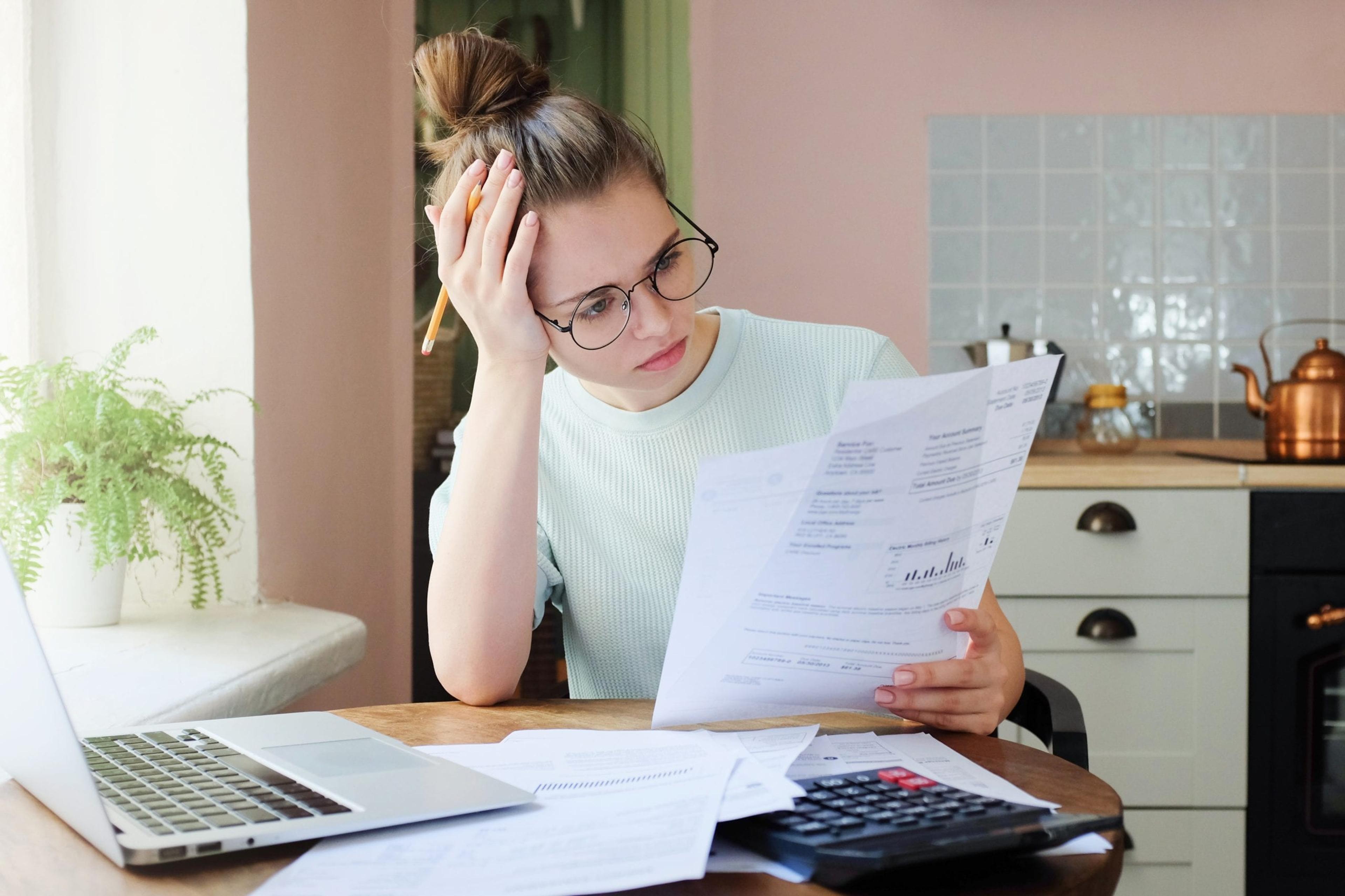 Young woman studying a bill.