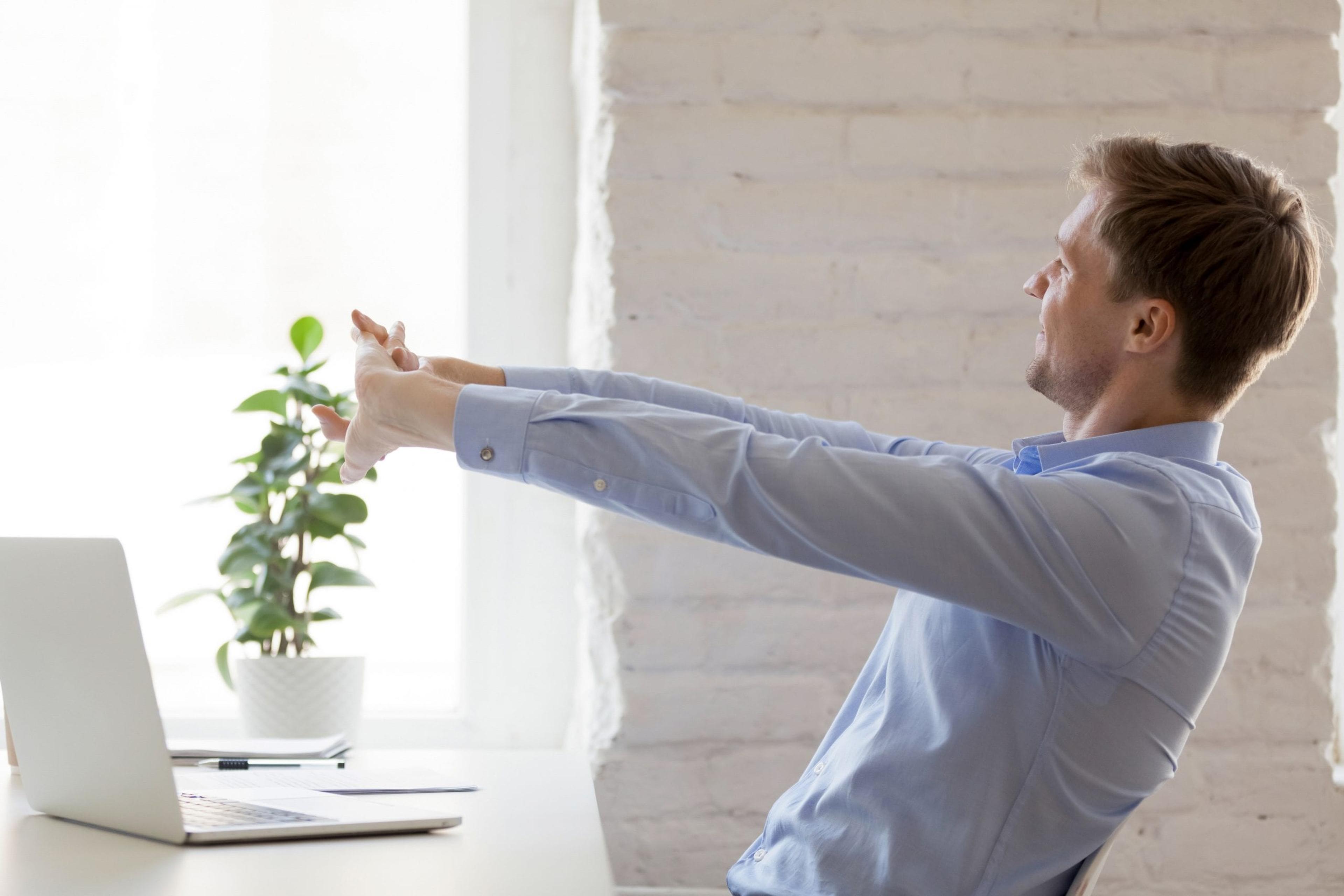 Digital detox: Man takes a stretch break while working