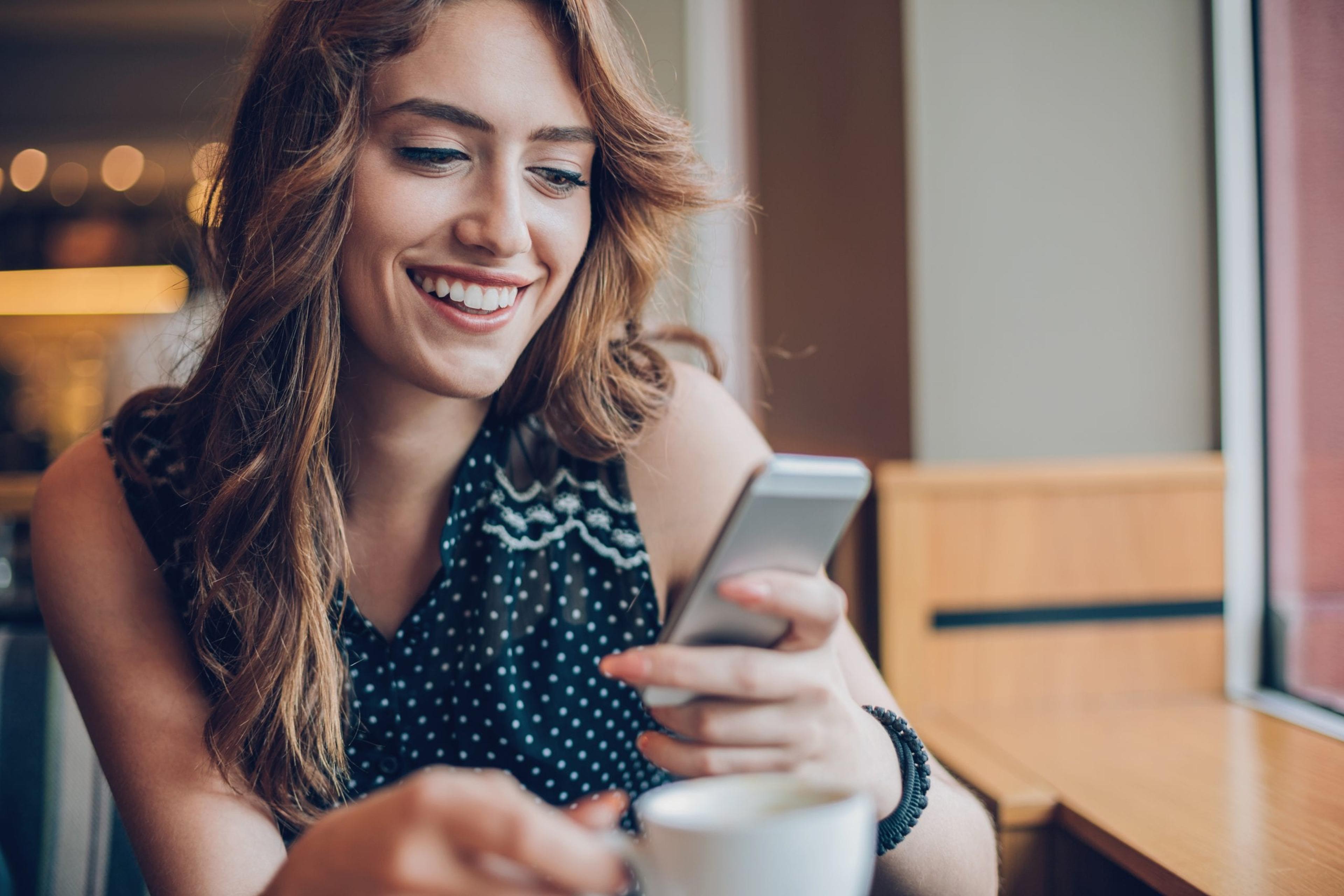 Woman smiling at her phone.