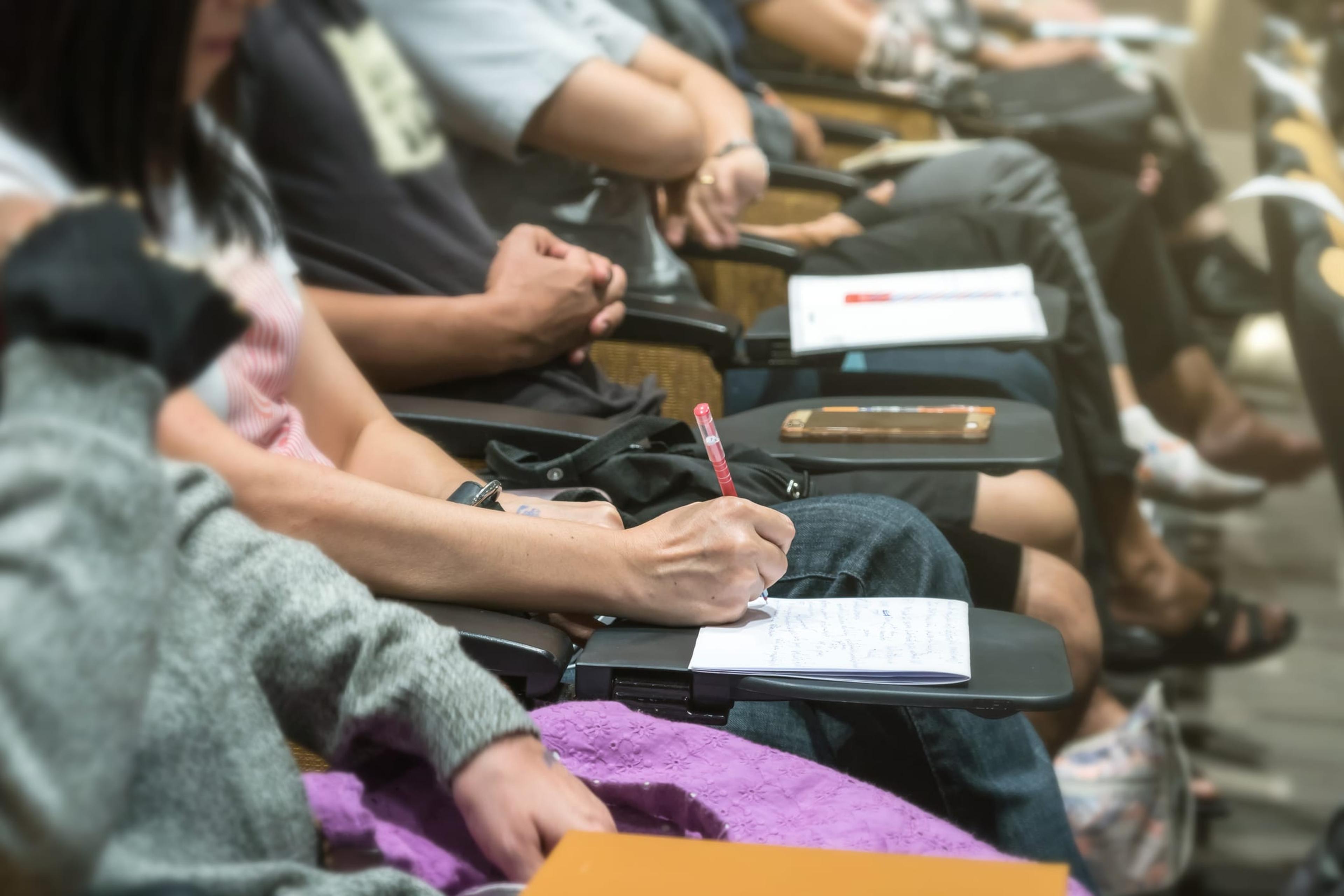 Students taking notes in a lecture hall.