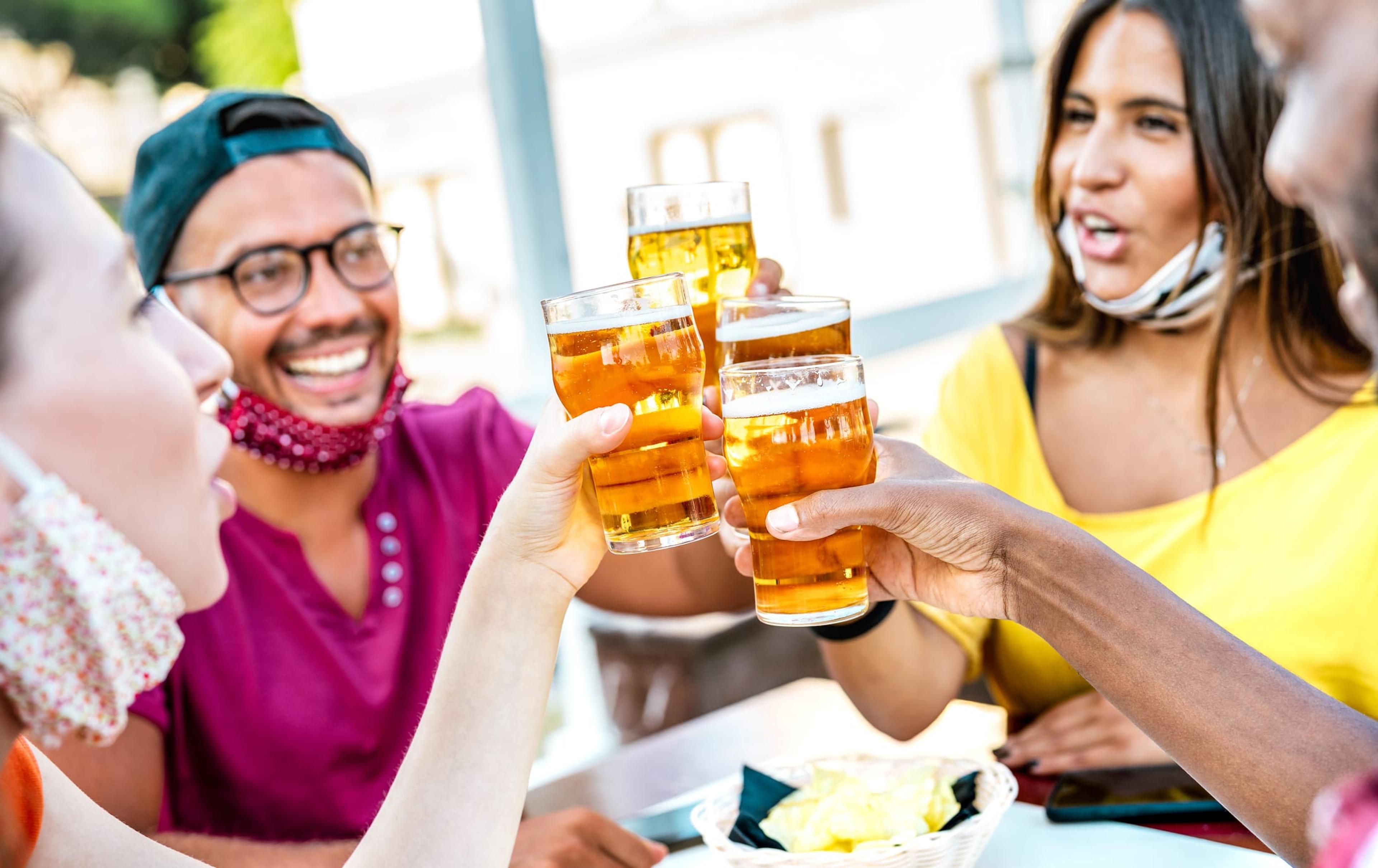 A group of young people toasting beer glasses