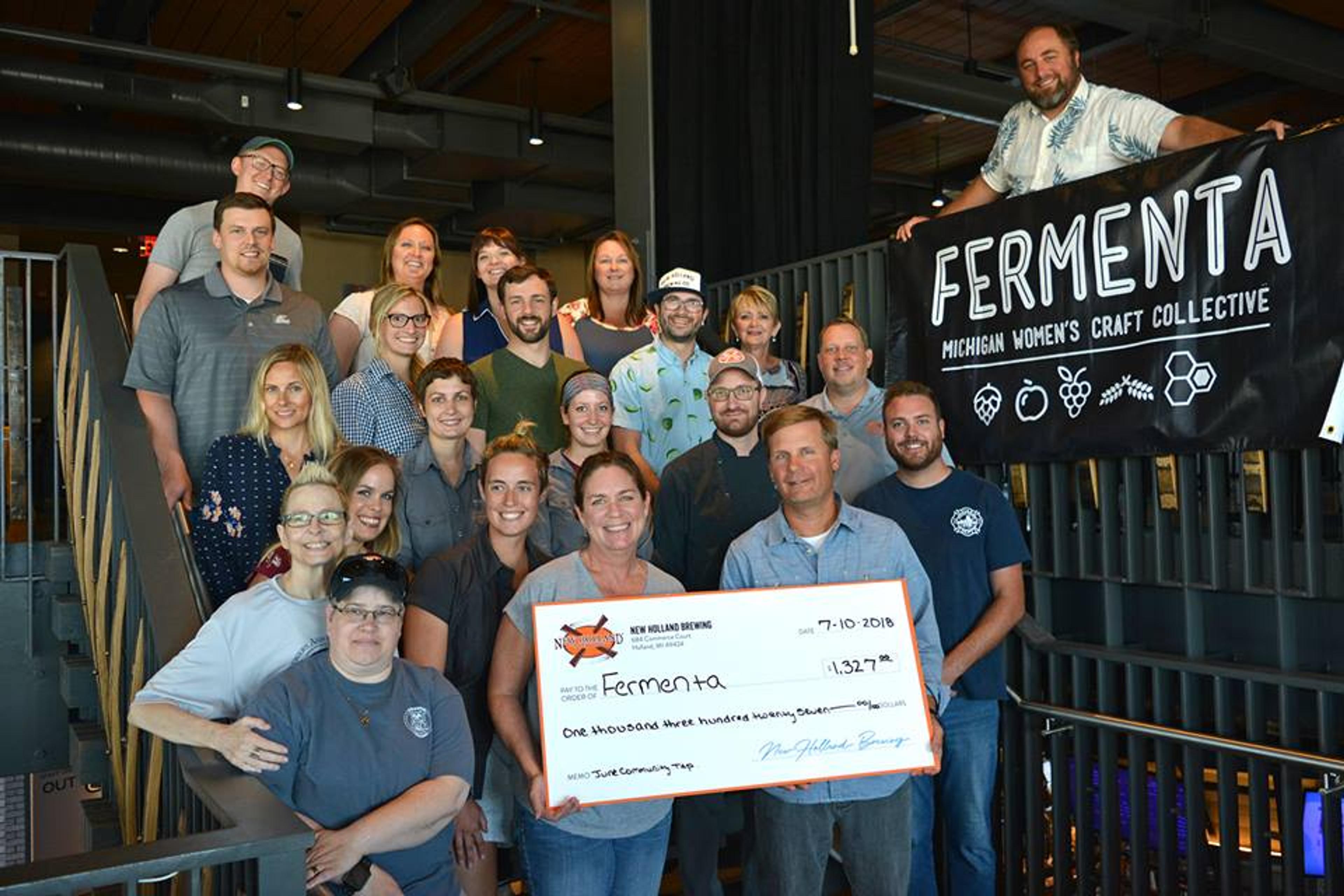 New Holland staff presenting a Community Tap check to members of Fermenta.
