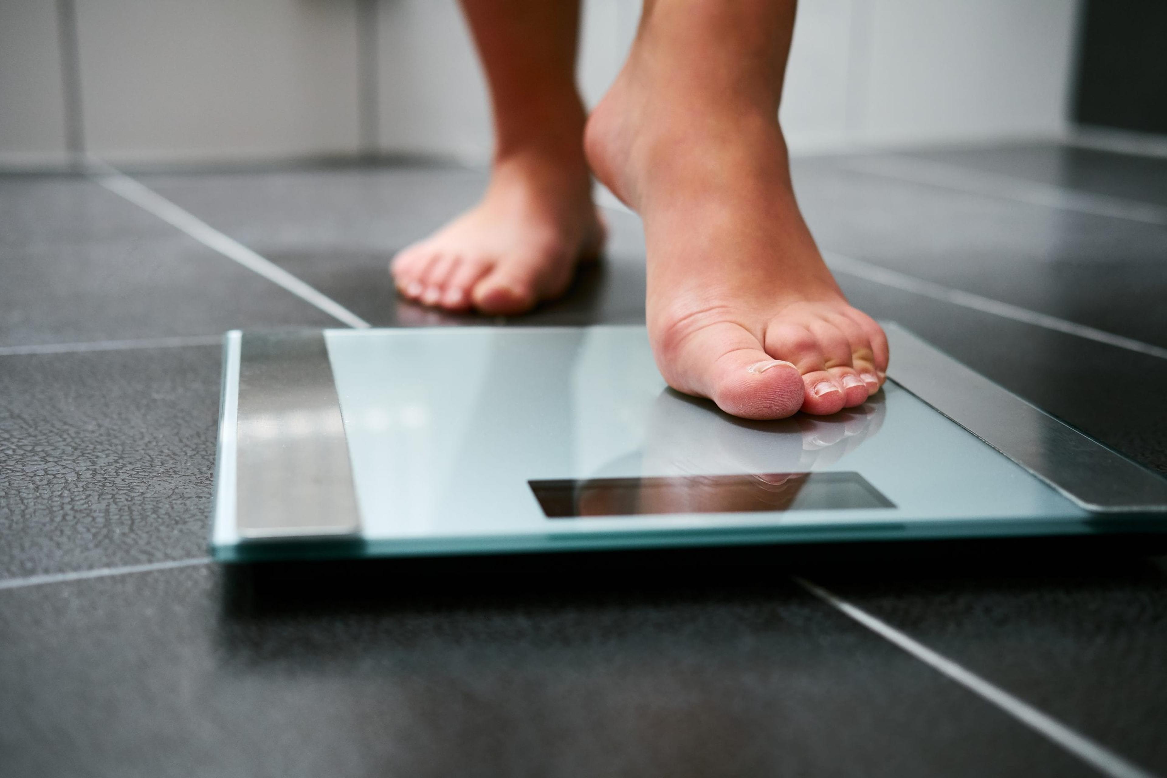 Female stepping onto an ominous looking scale