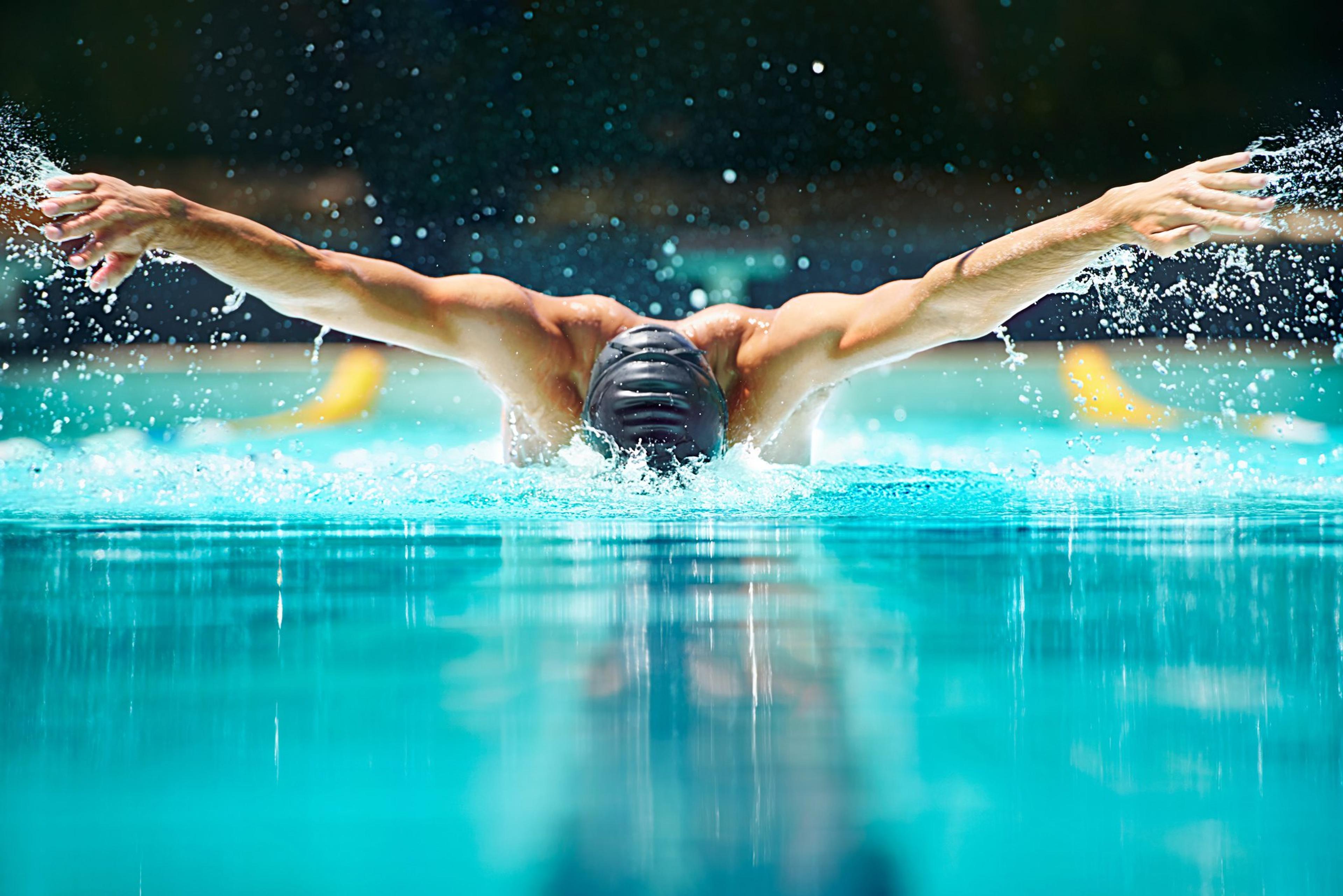 A swimmer completes a butterfly stroke in the pool