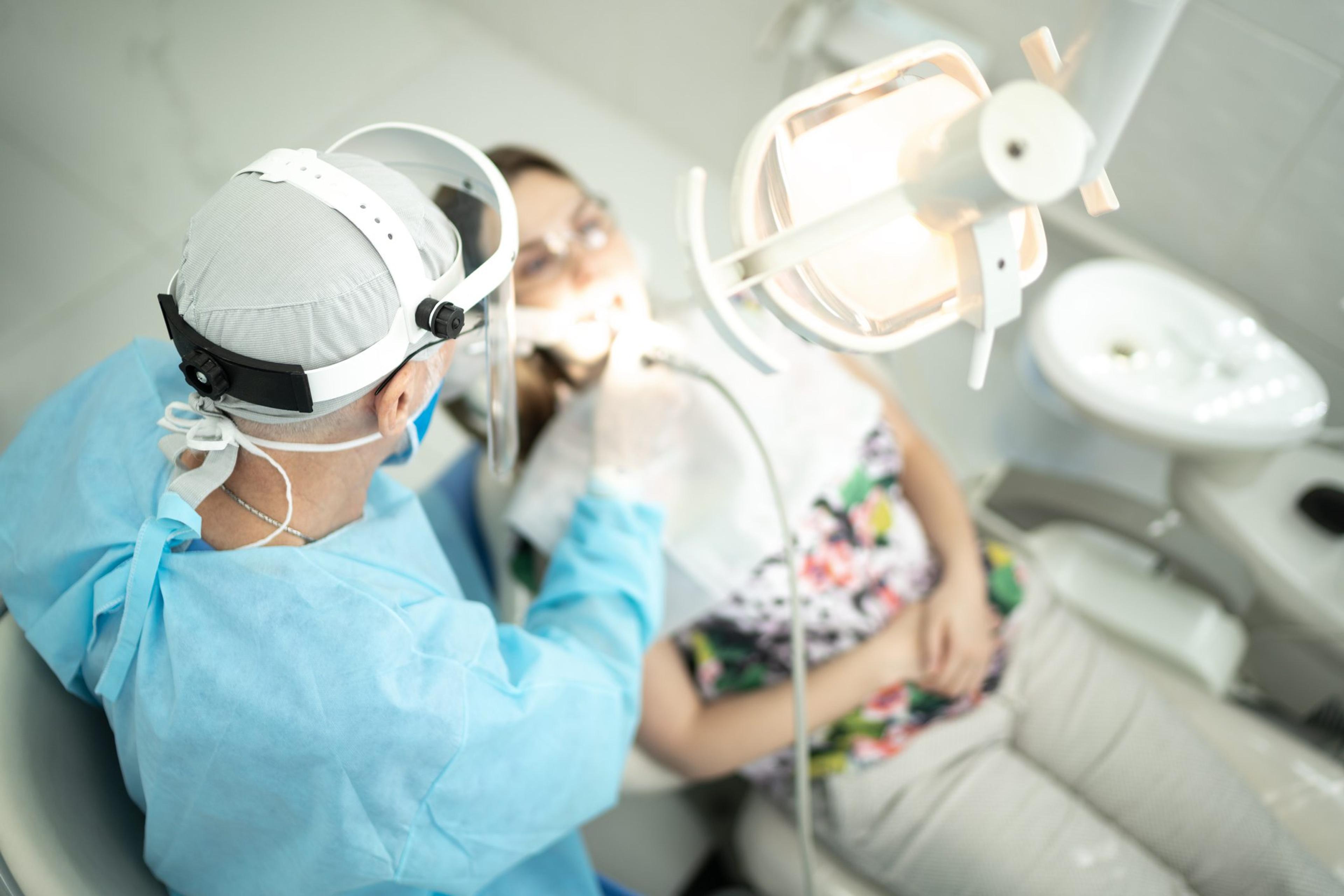 Dentist in PPE working with a patient
