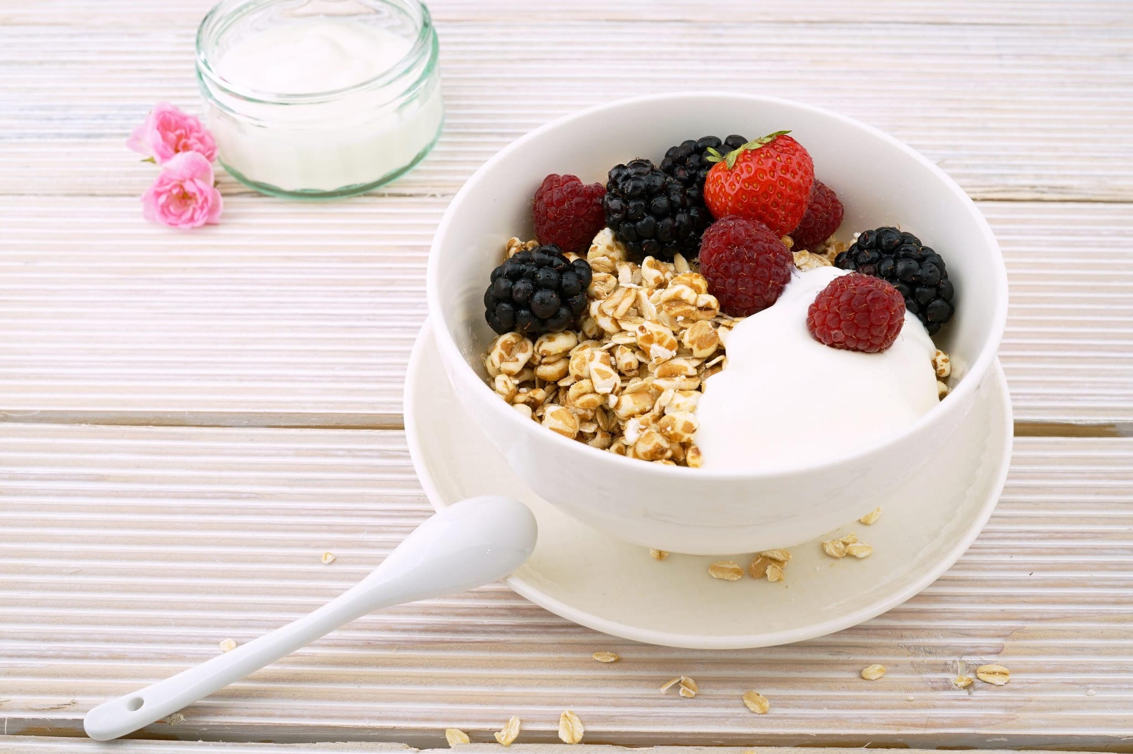 Image of plain yogurt topped with granola and berries.