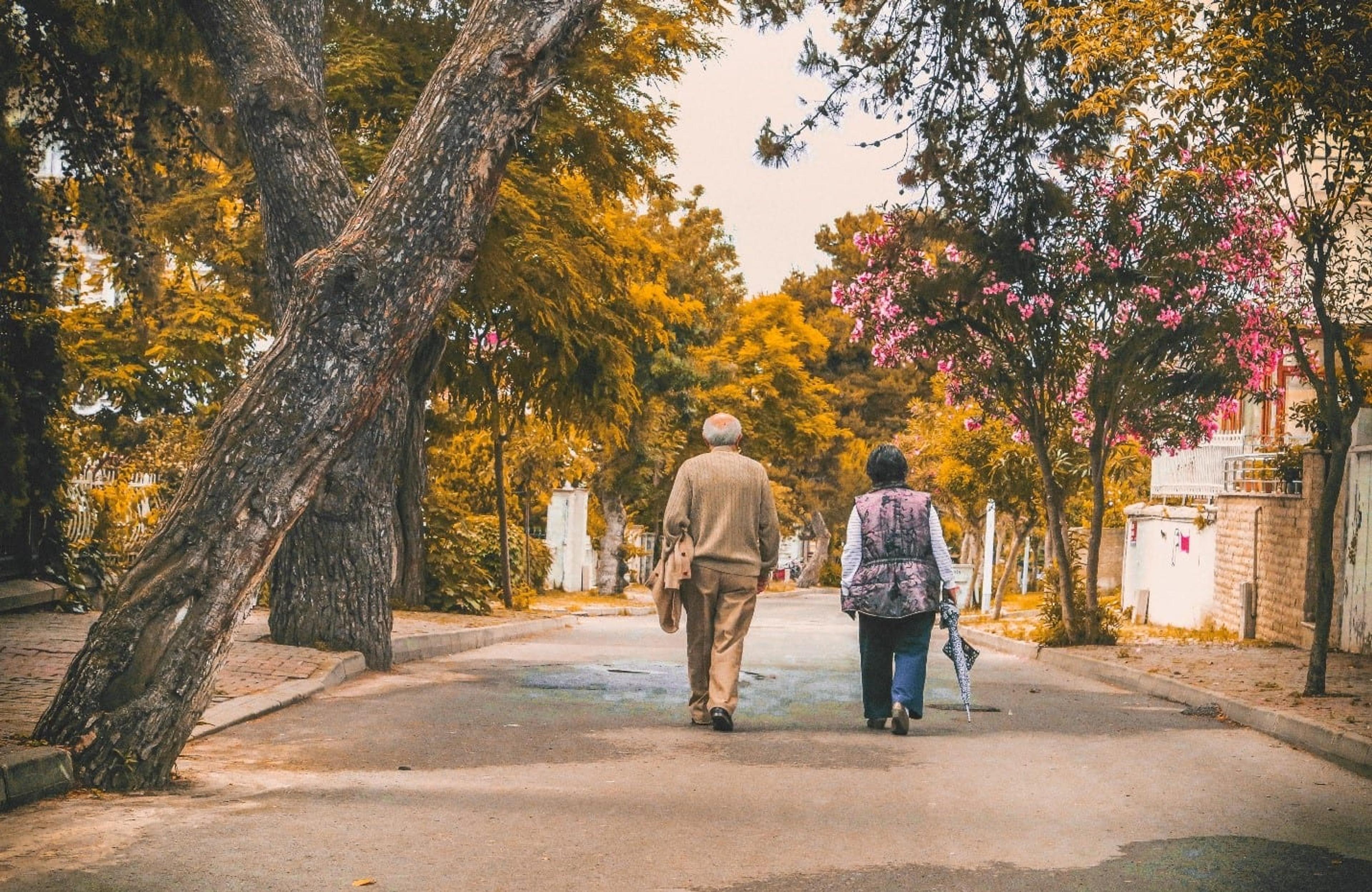 An elderly couple walking down a street