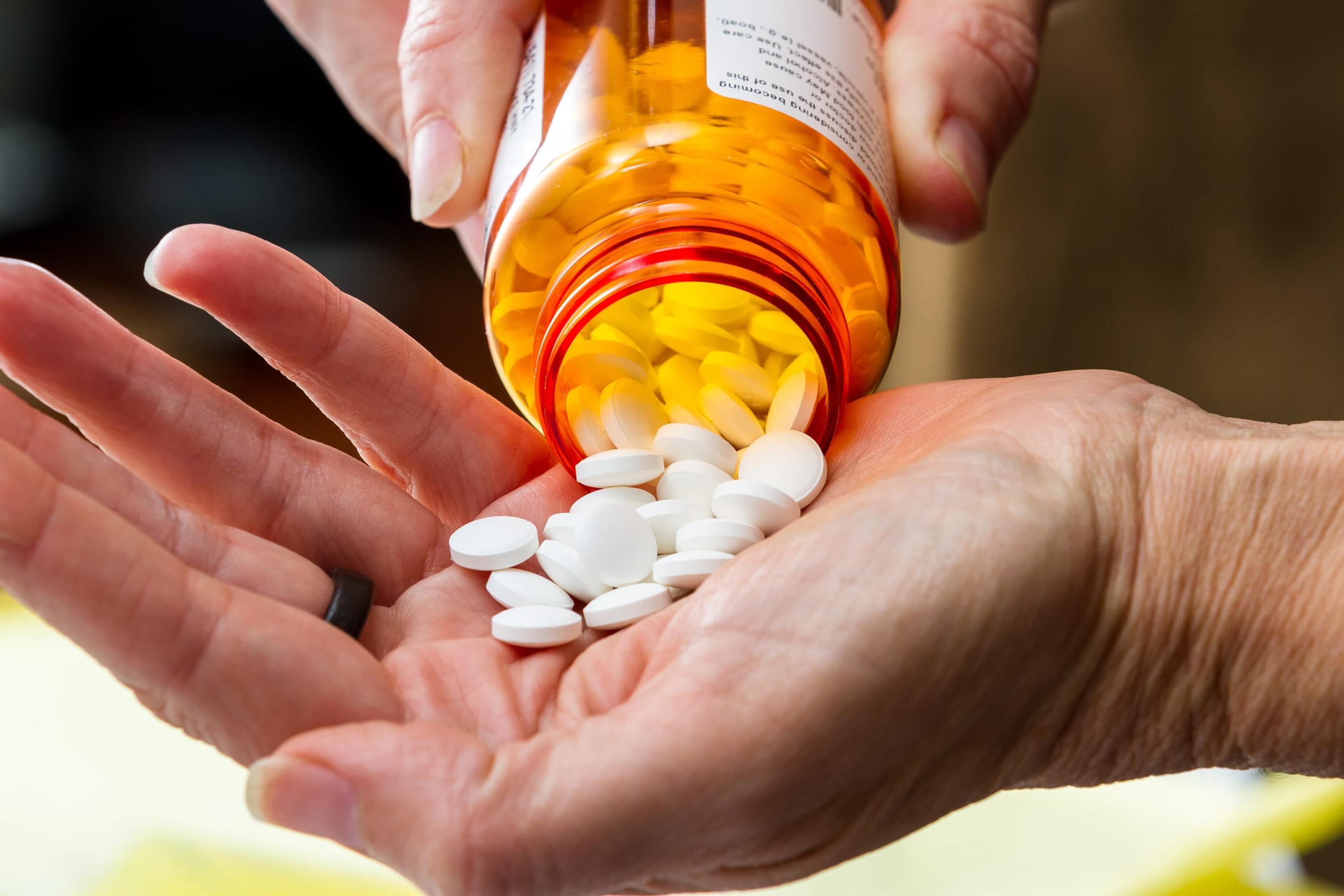 Close up of a hand holding prescription pills