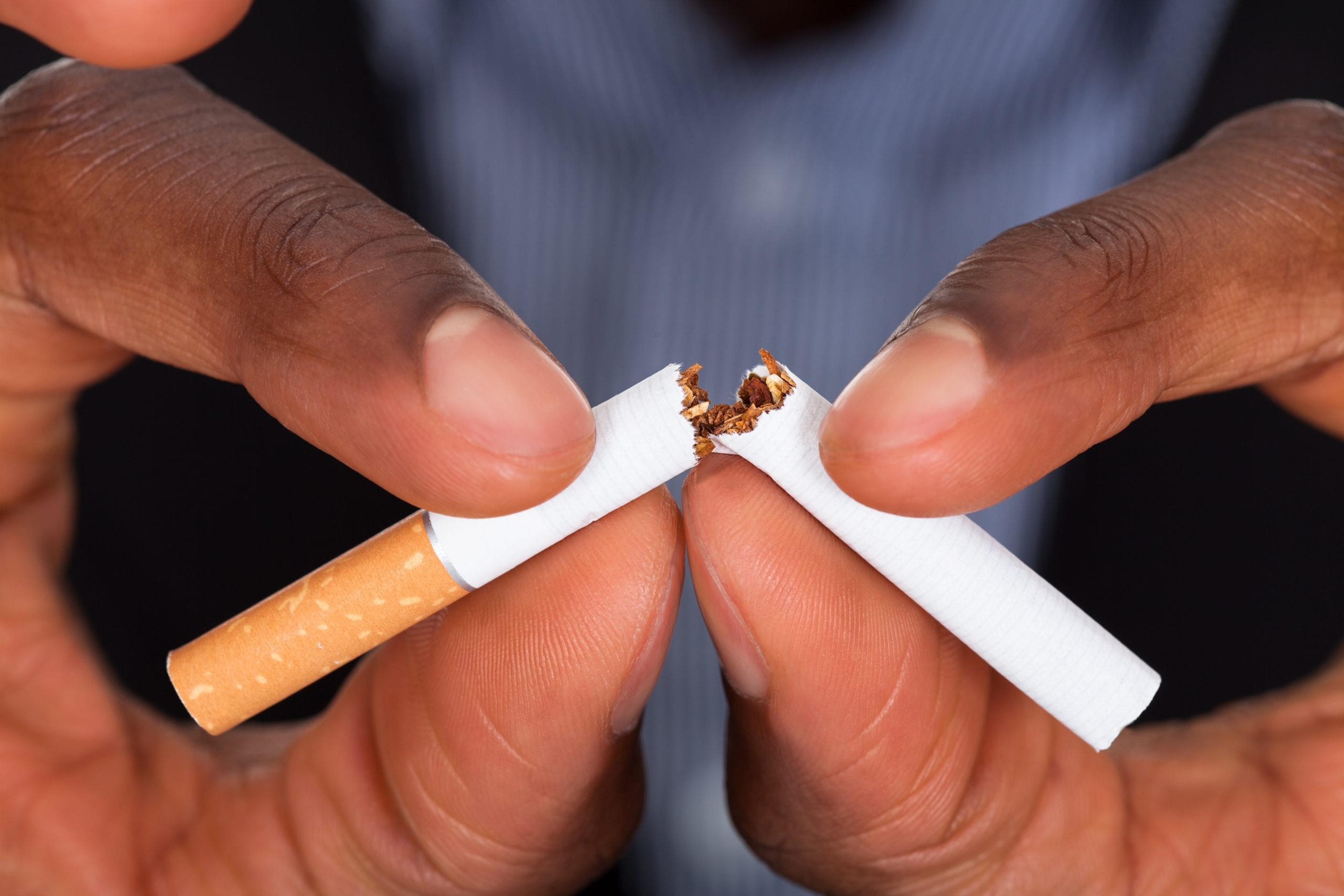 Hands breaking cigarette in half