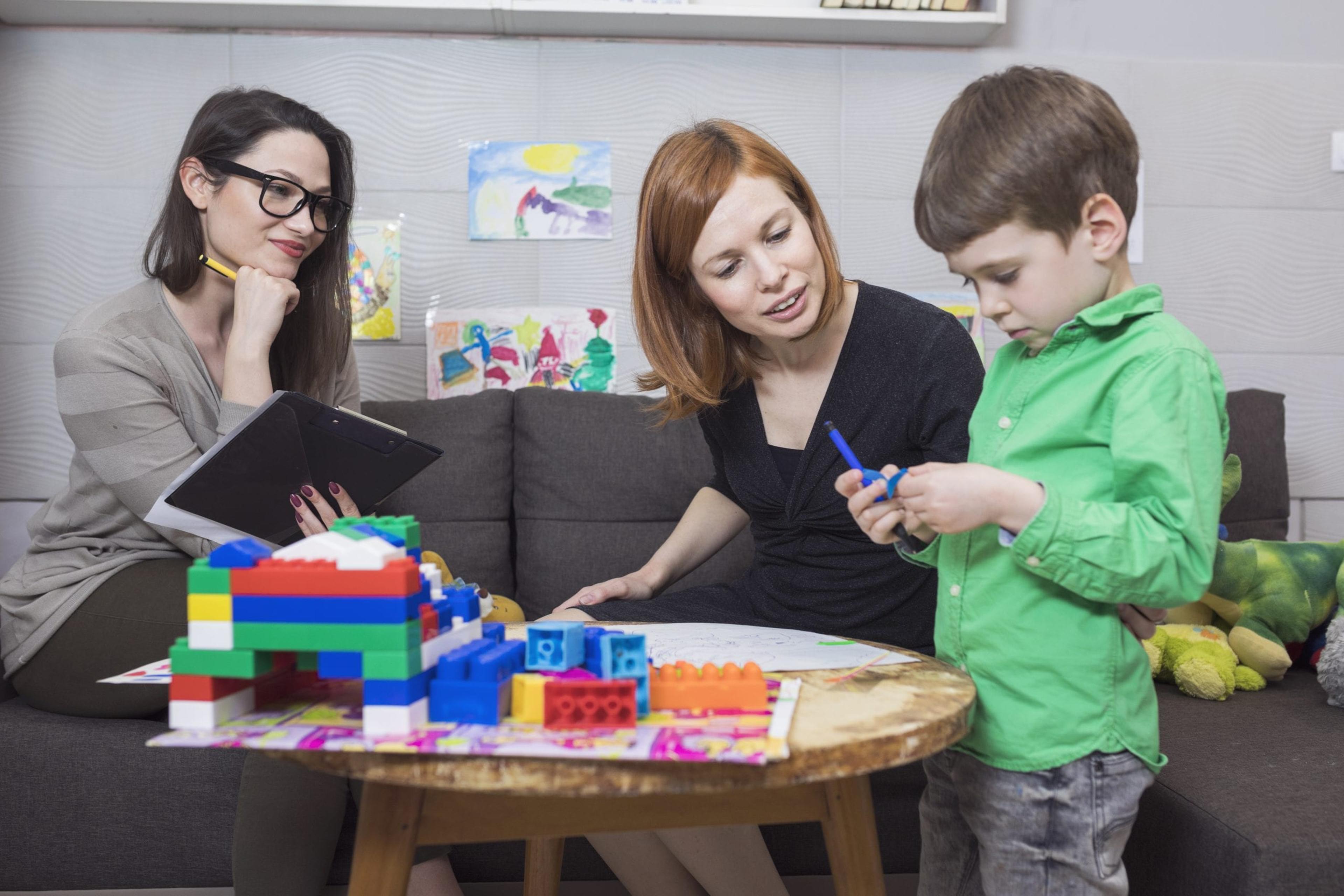 Child psychologist working with a child and his mother