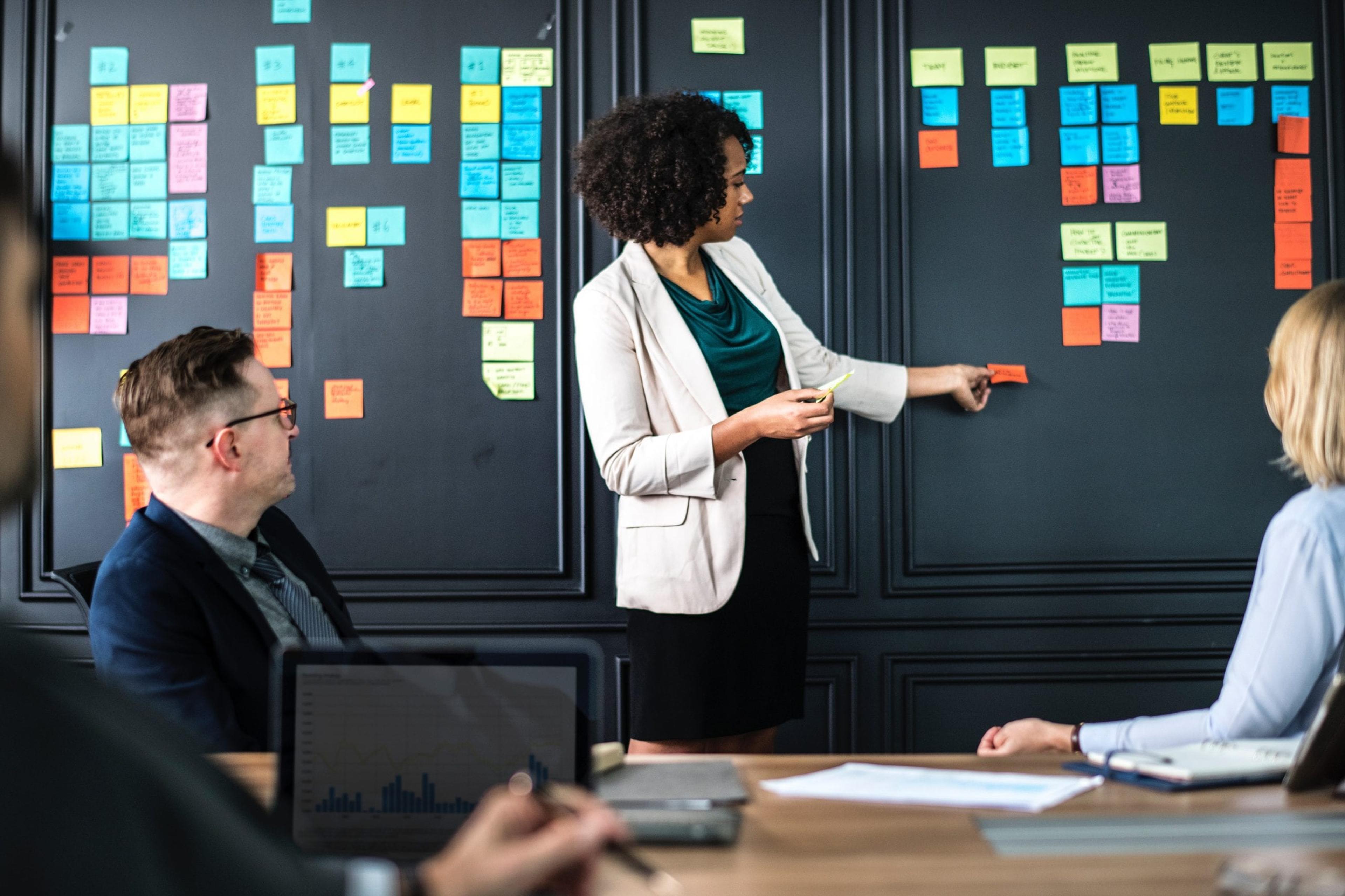 Woman presenting at front of conference room