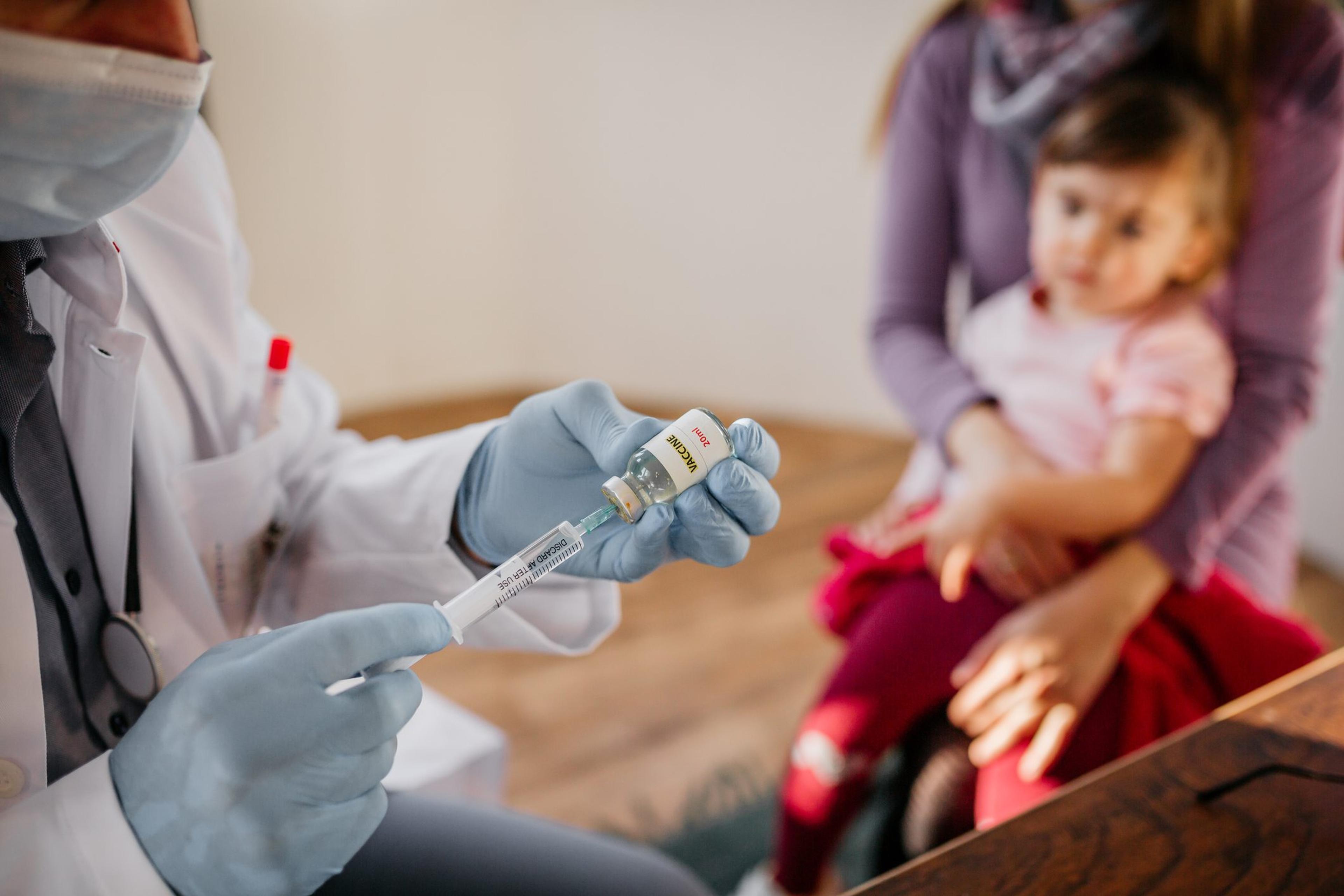 Health care provider prepares to give a COVID vaccine to a child under age 5