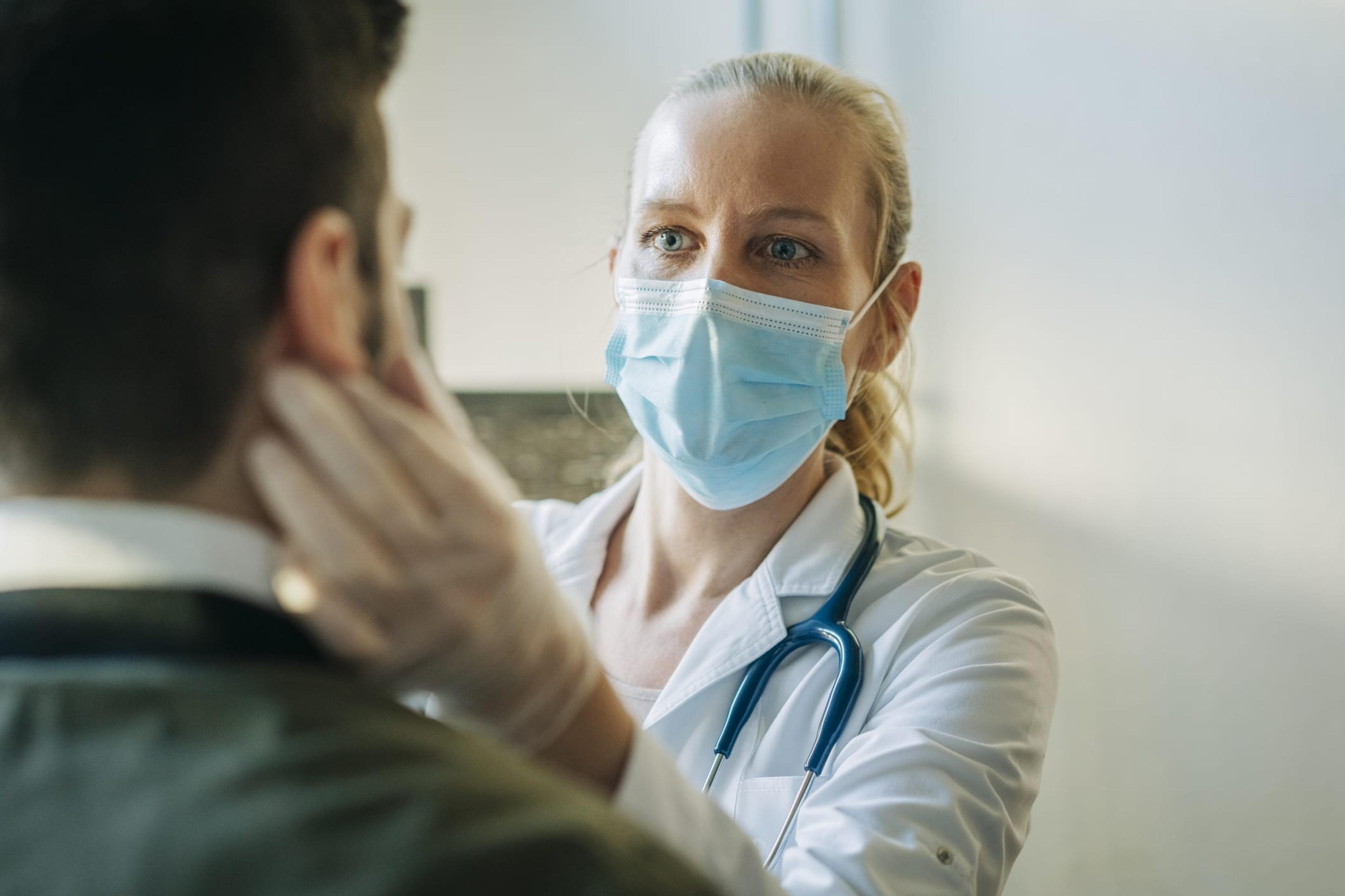Doctor wearing a mask examining a patient