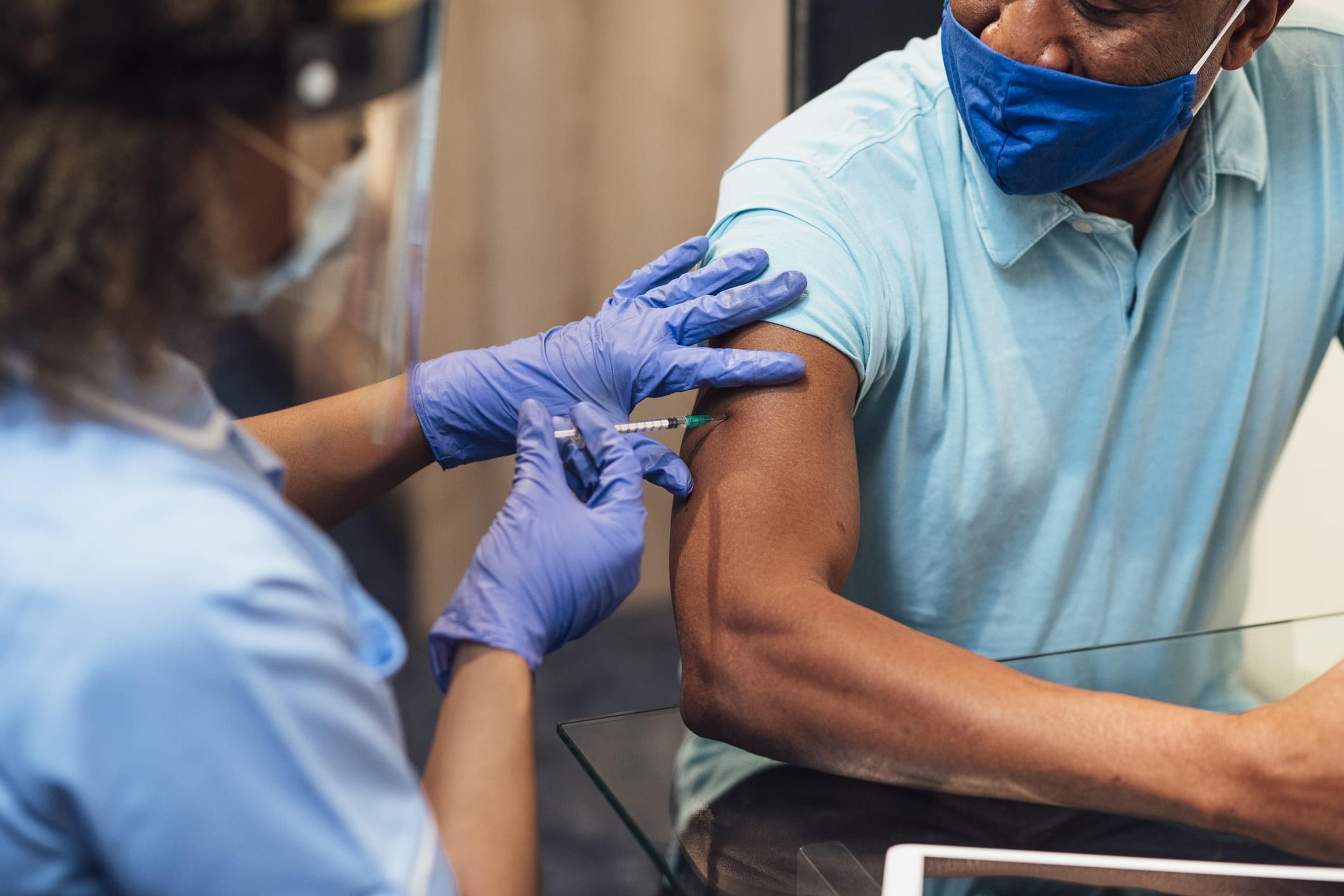 Man receiving a vaccine in his arm