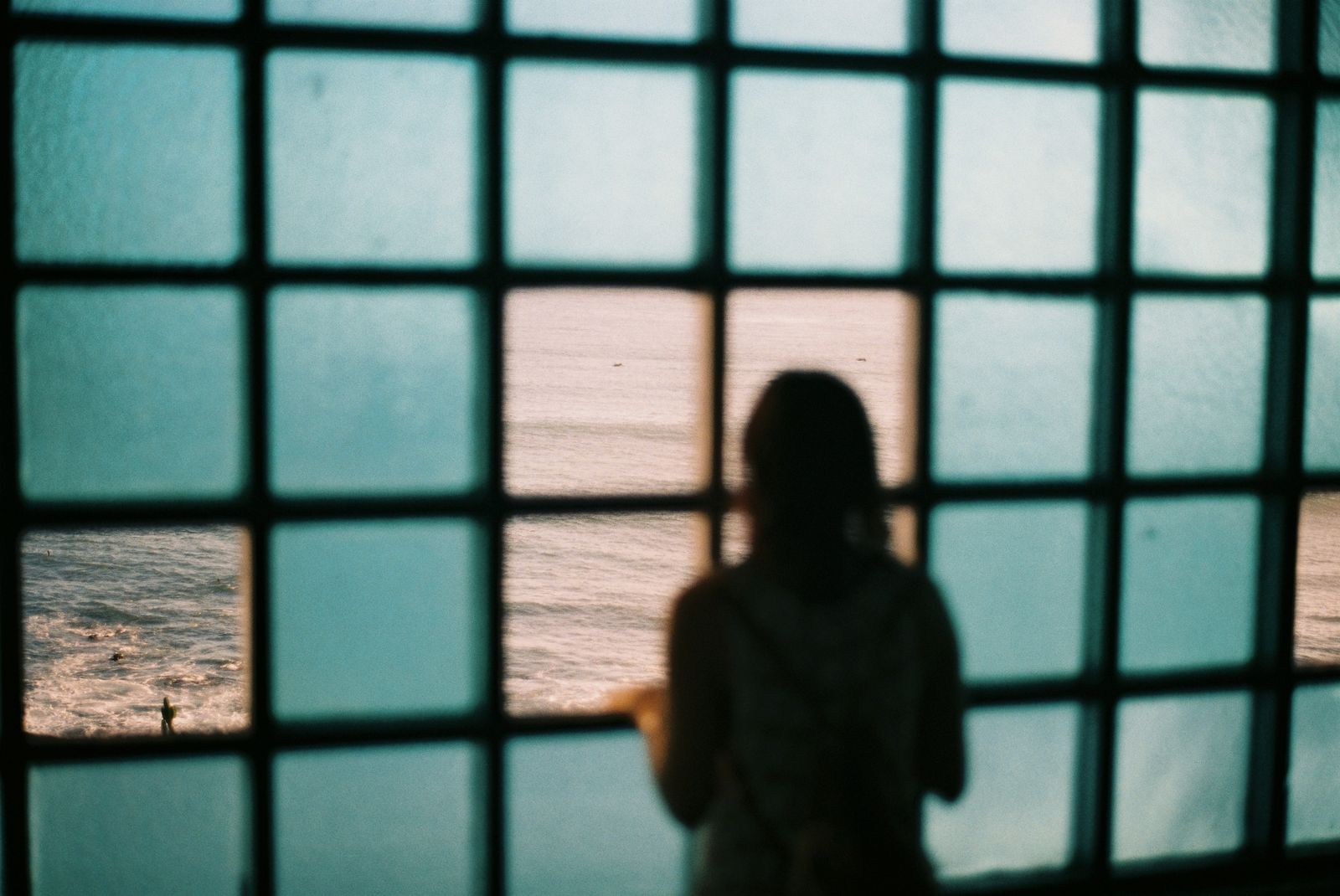 Shadow of person ooking out window at ocean