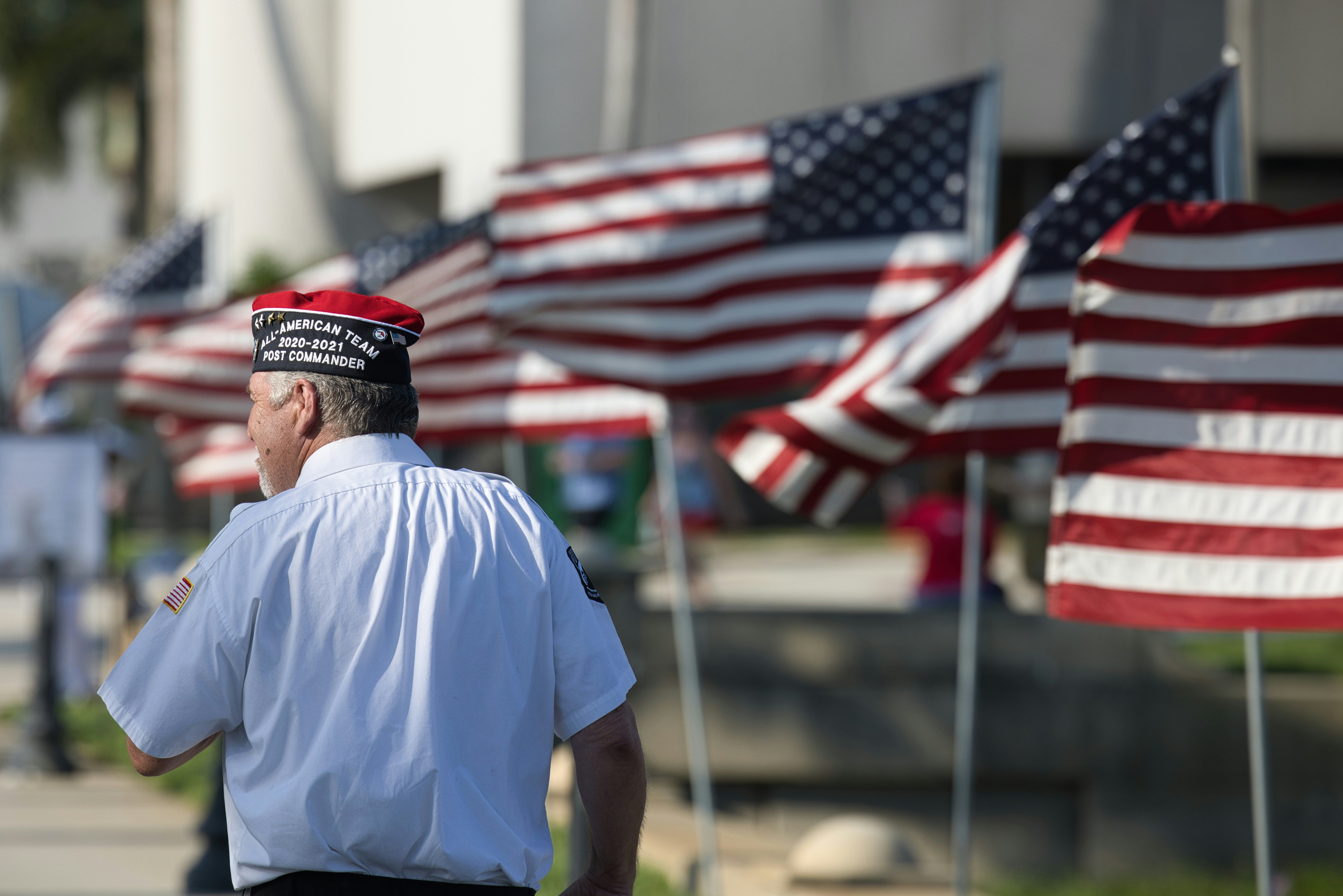 Veteran in front of American flags