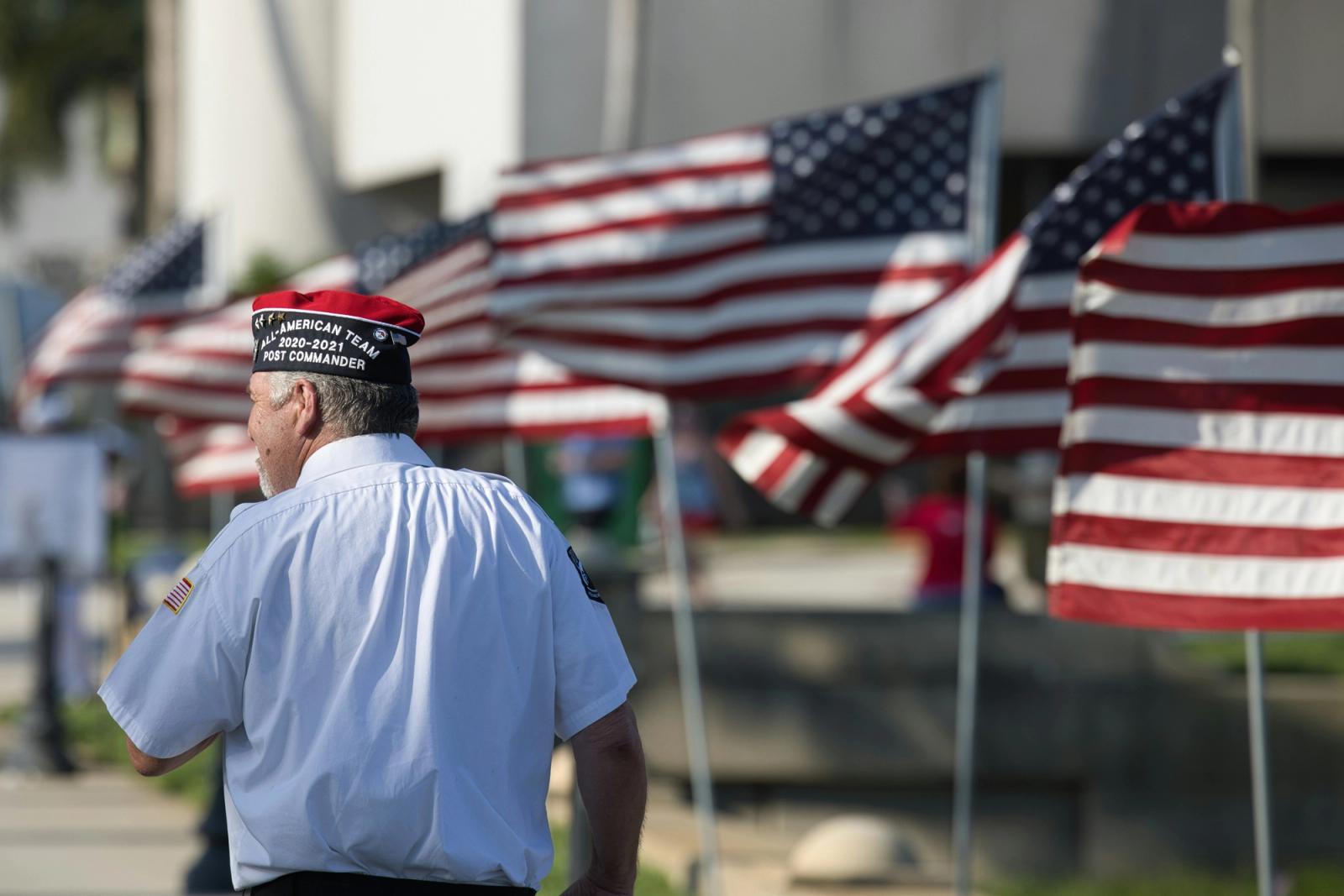 Veteran in front of American flags