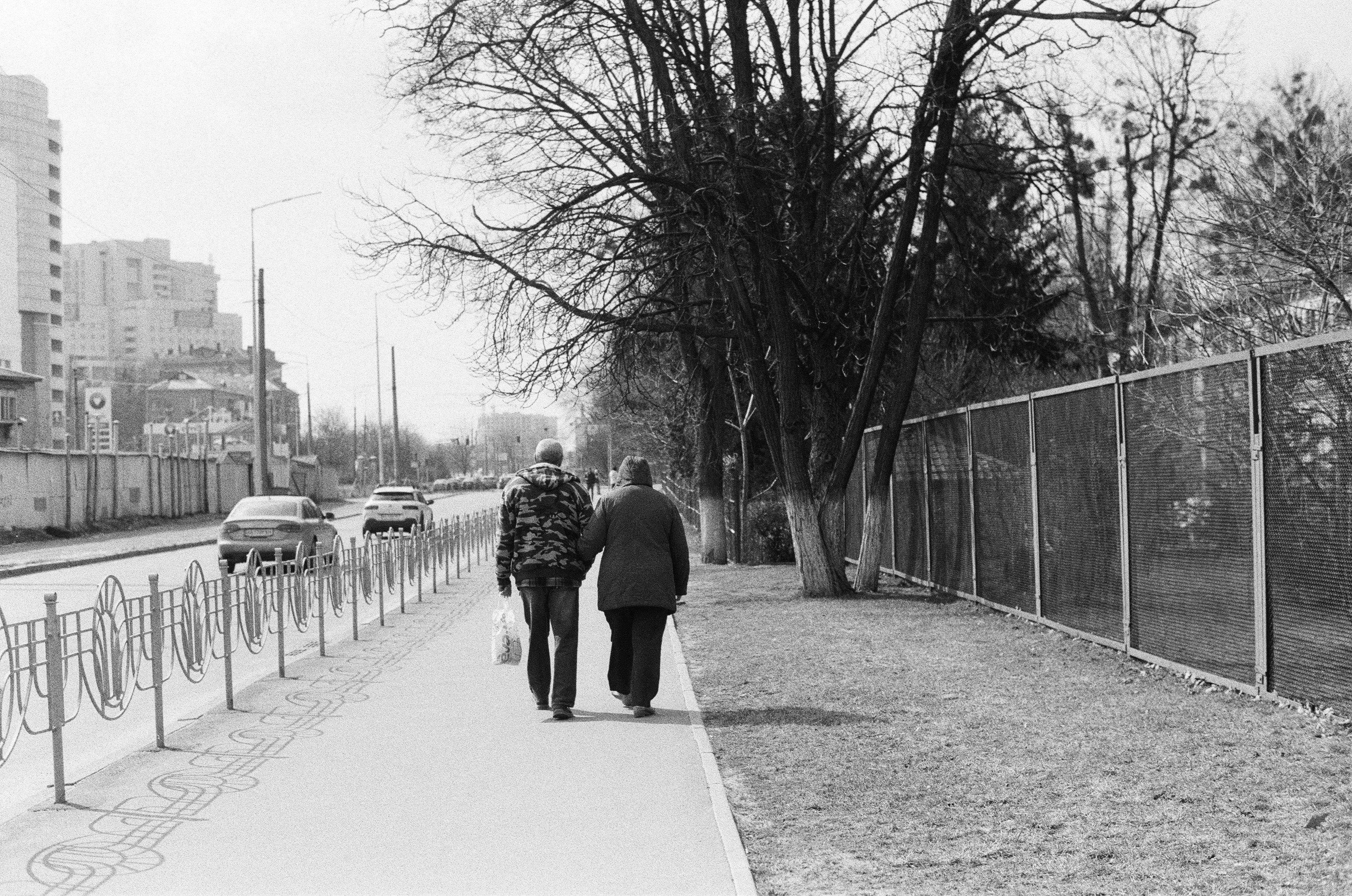 Older couple walking down street, black and white