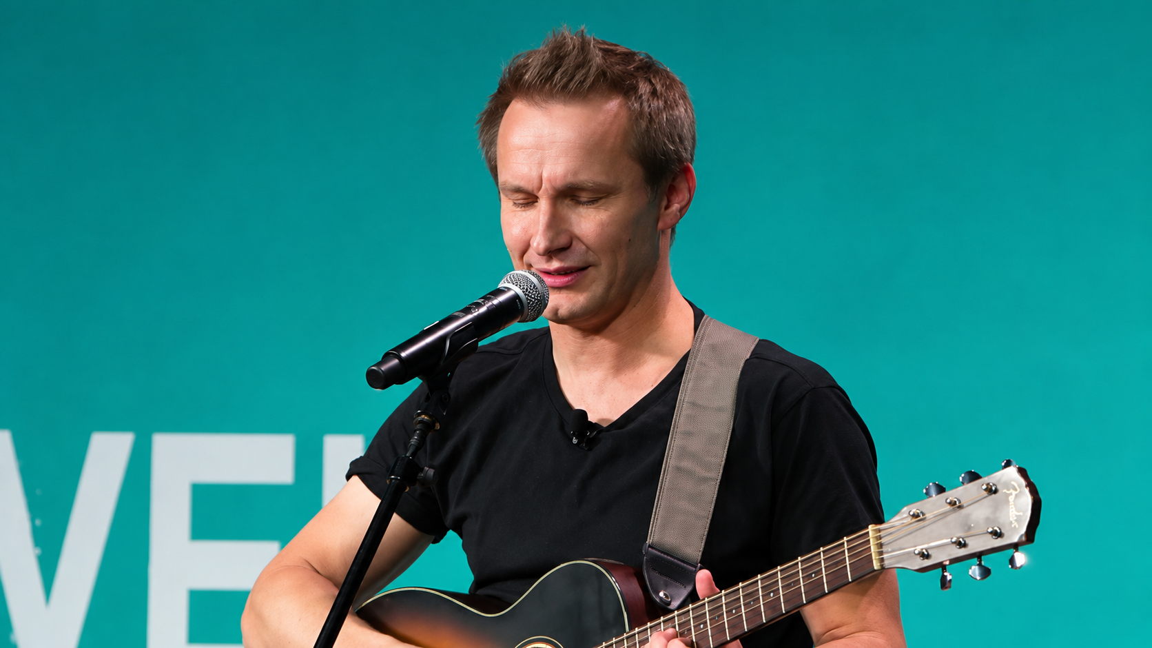 man with guitar on stage